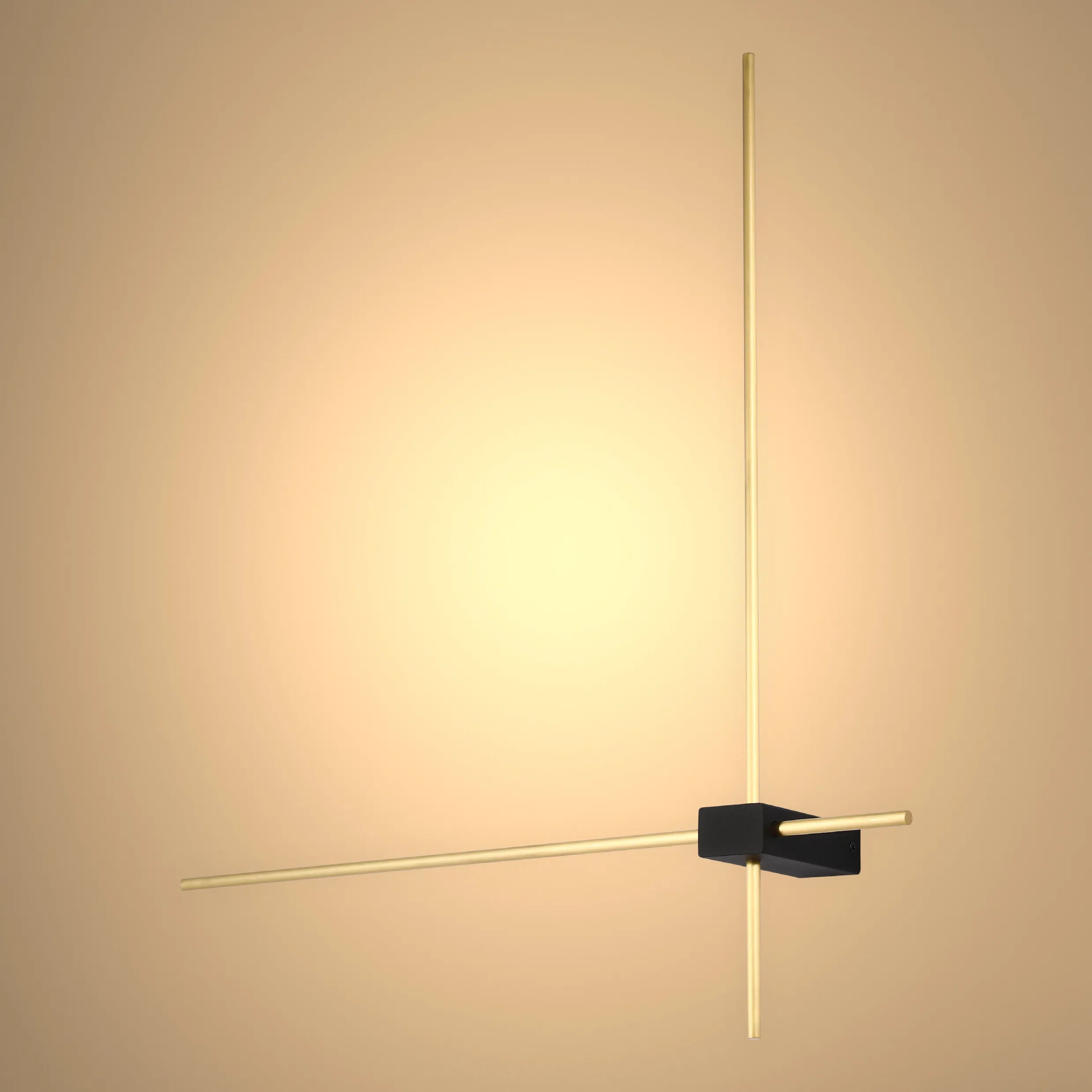A modern, minimalist wall light fixture with brass rods intersecting through a black rectangular centre on a peach background.
