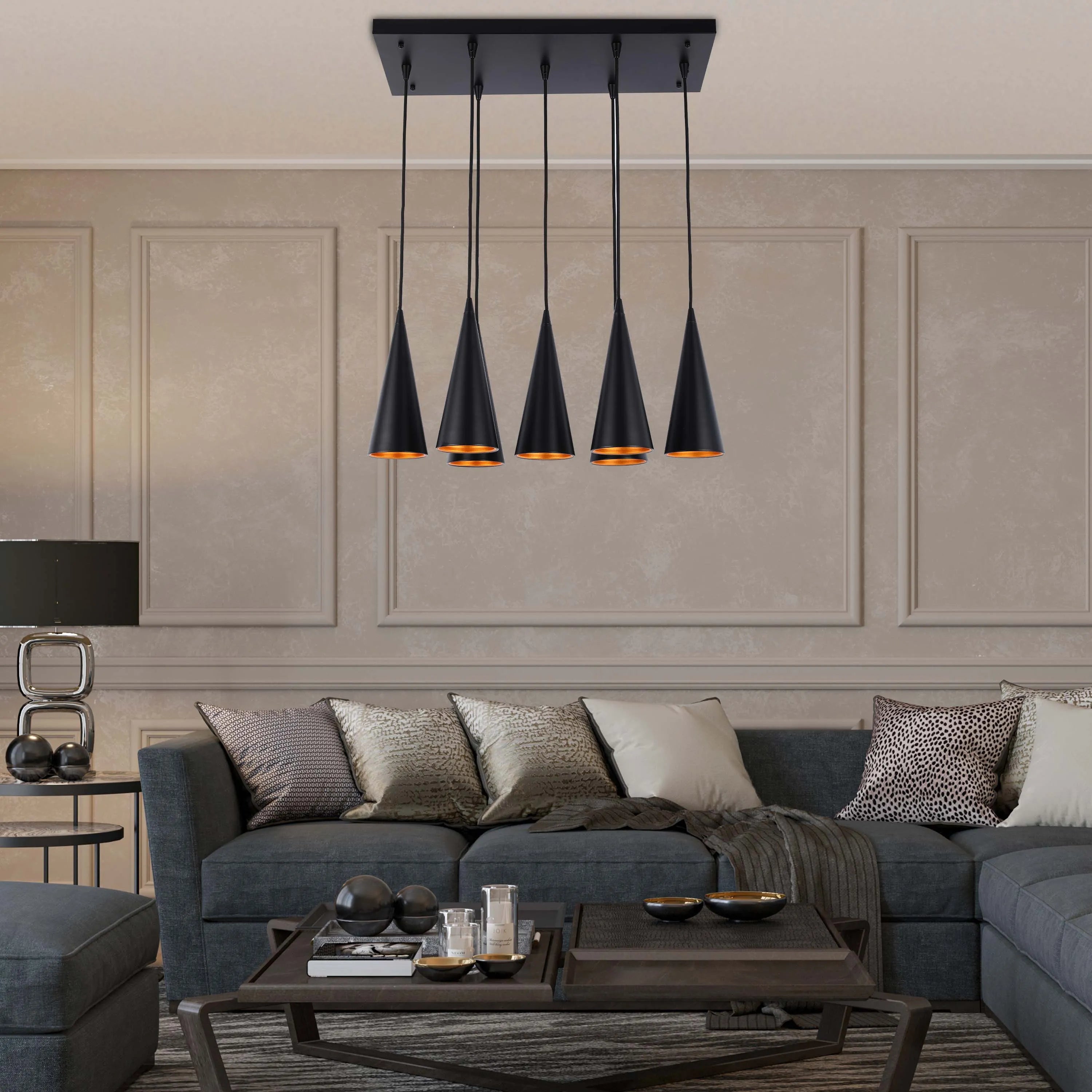 A contemporary linear pendant light with five cone-shaped shades, suspended over a living space.