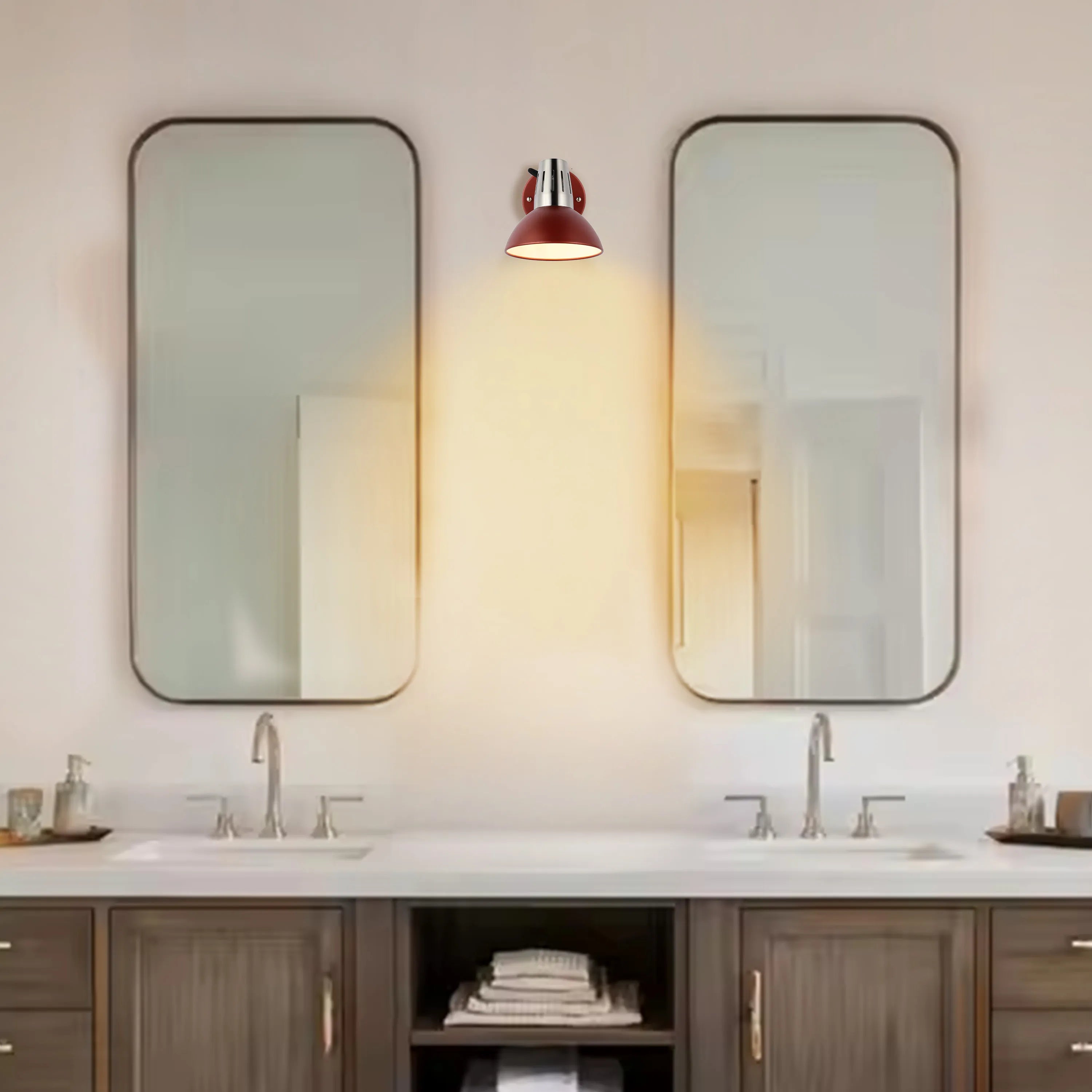 A charming, dark red sconce casts a warm glow between two large rectangular mirrors above a bathroom vanity.