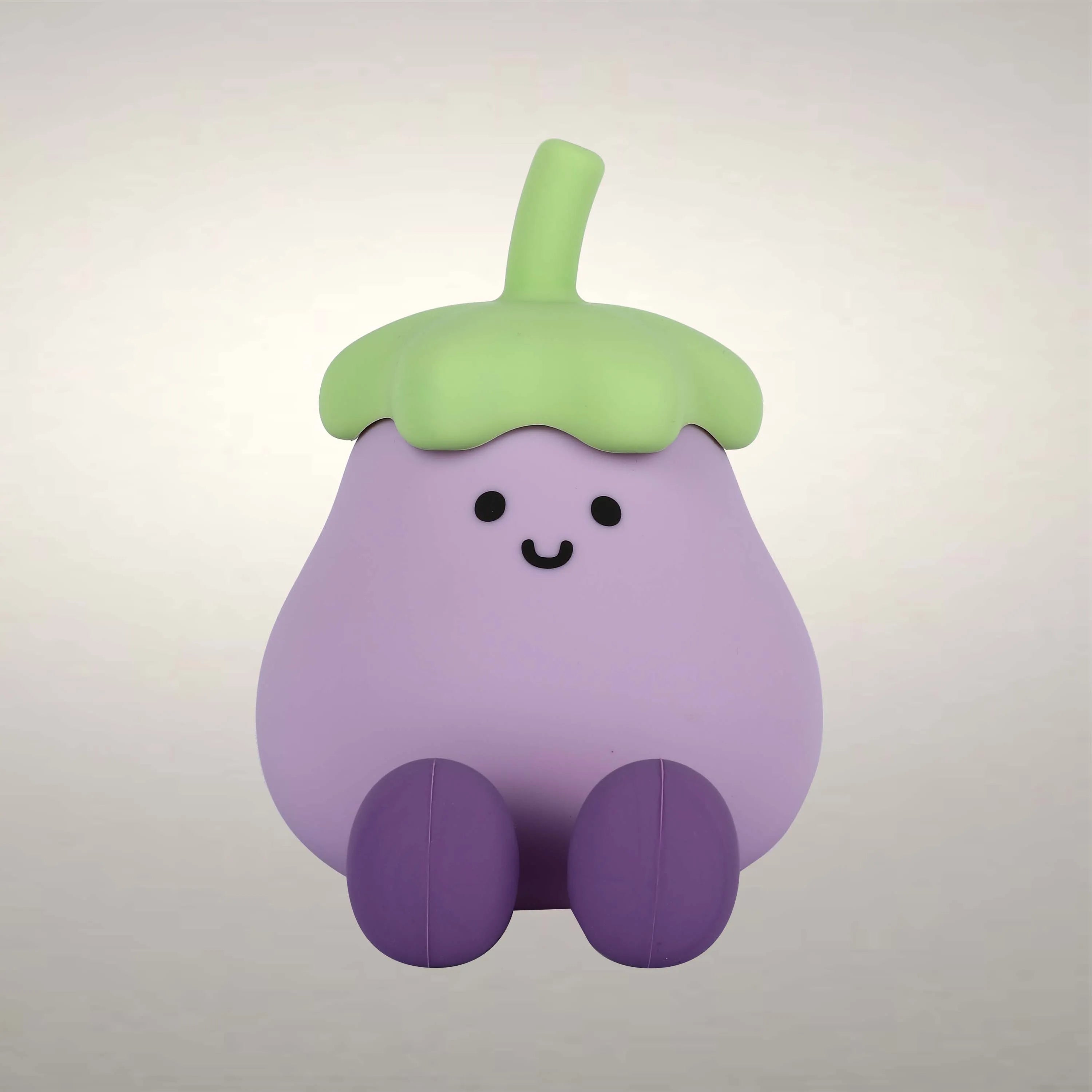 Soft, even lighting highlights the cute, cartoonish design of a smiling, purple eggplant with green top and darker purple legs.