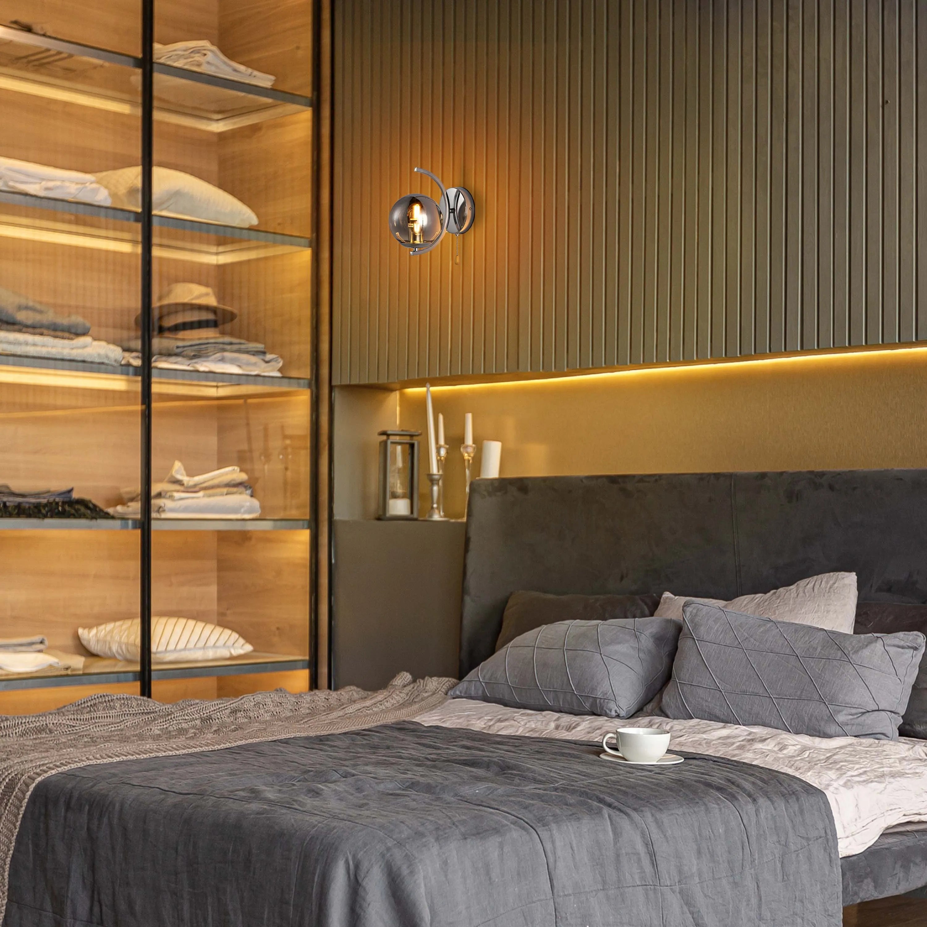 Wall-mounted lighting shines above a bed in this lifestyle shot, creating a warm and inviting atmosphere.