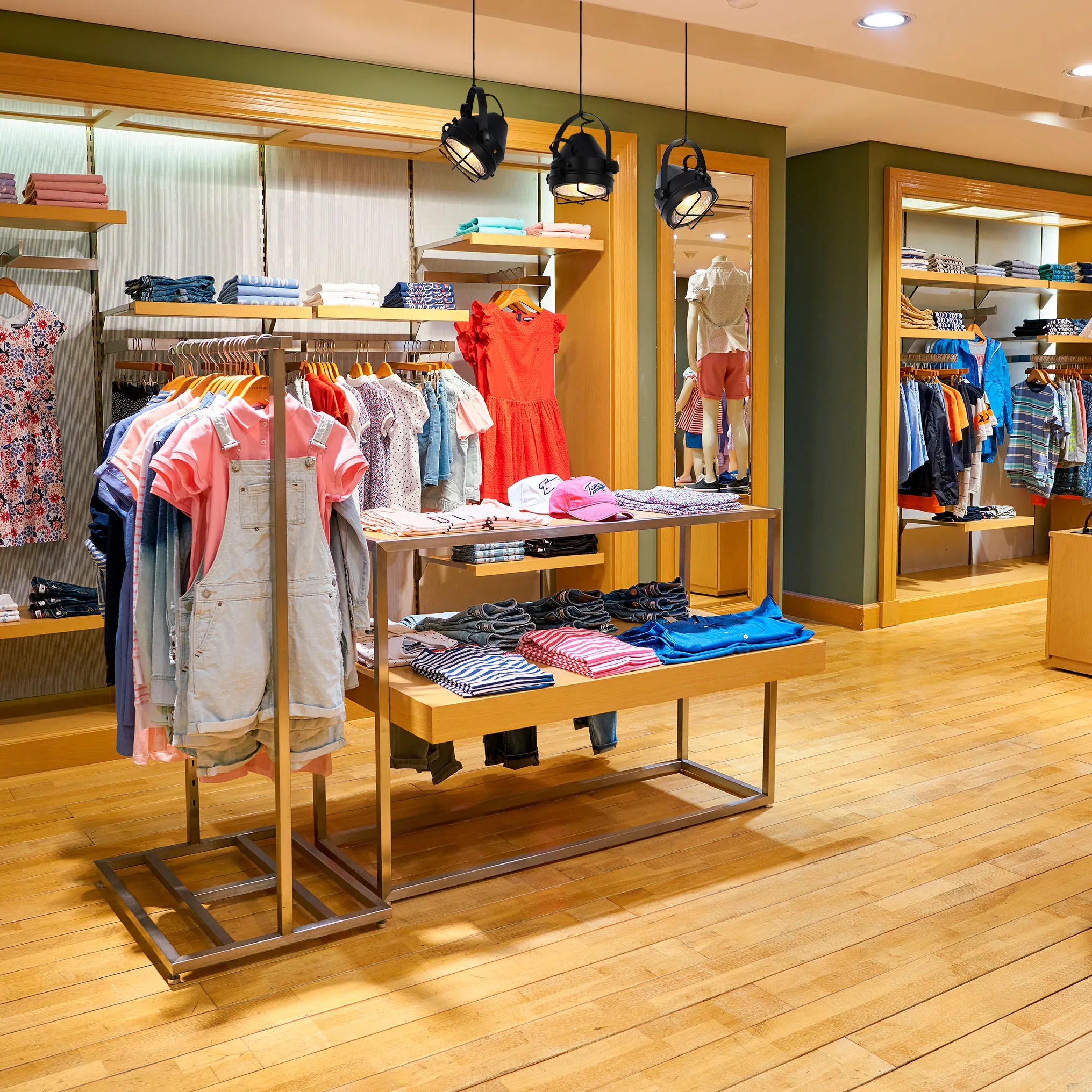 The clothing store features a combination of recessed ceiling lights and industrial-style pendant lights, providing ambient and accent lighting.