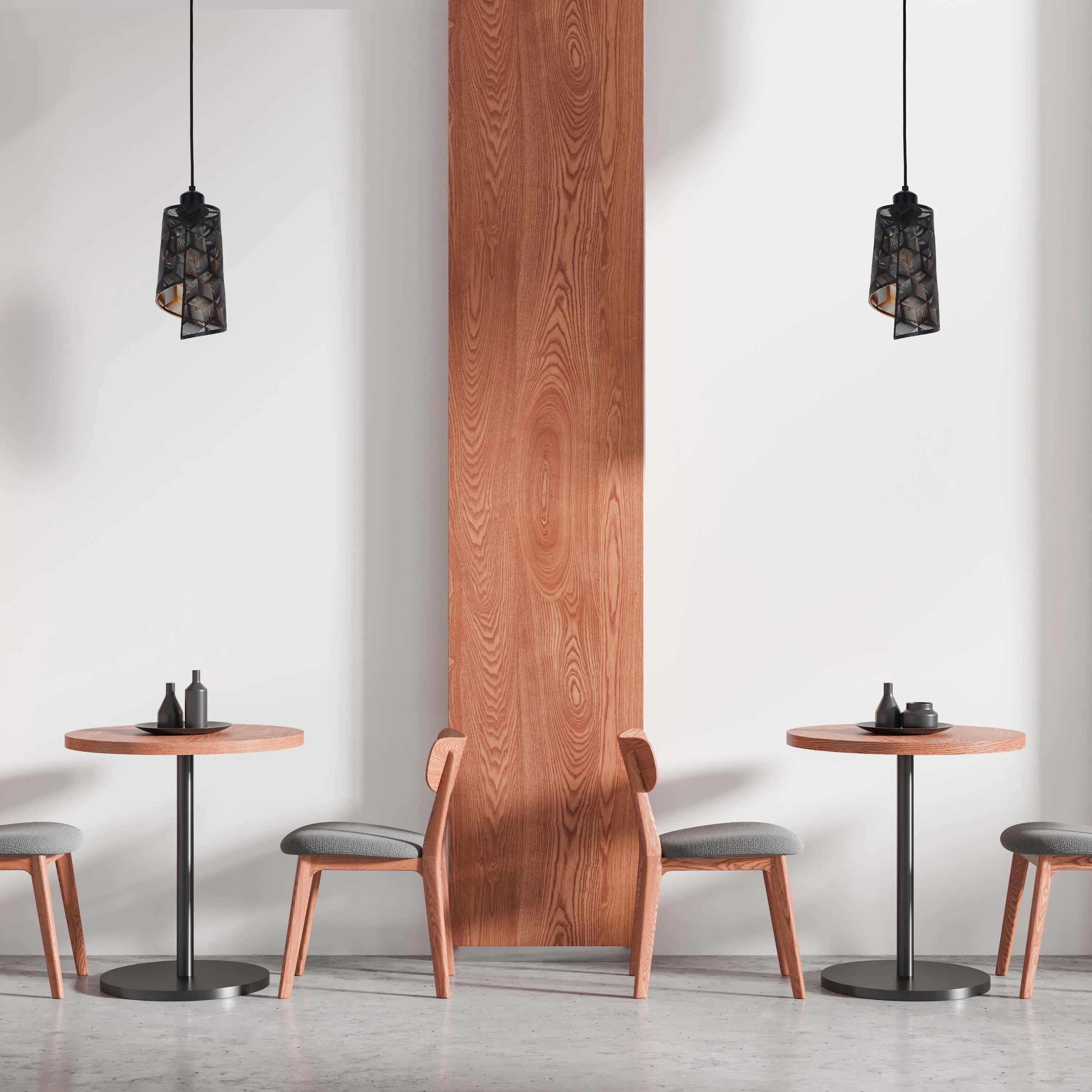 Two modern black pendant lights illuminate cafe tables with warm wood and sleek black accents, enhancing a minimalist, chic atmosphere.
