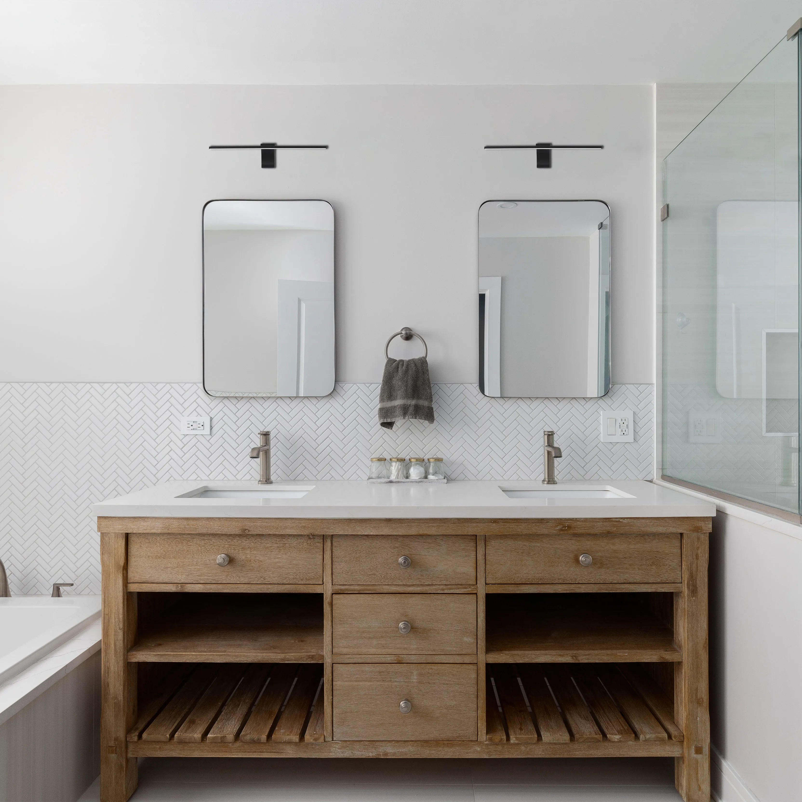 Two contemporary black light fixtures above twin mirrors illuminate this bathroom vanity with a light, stylish touch.