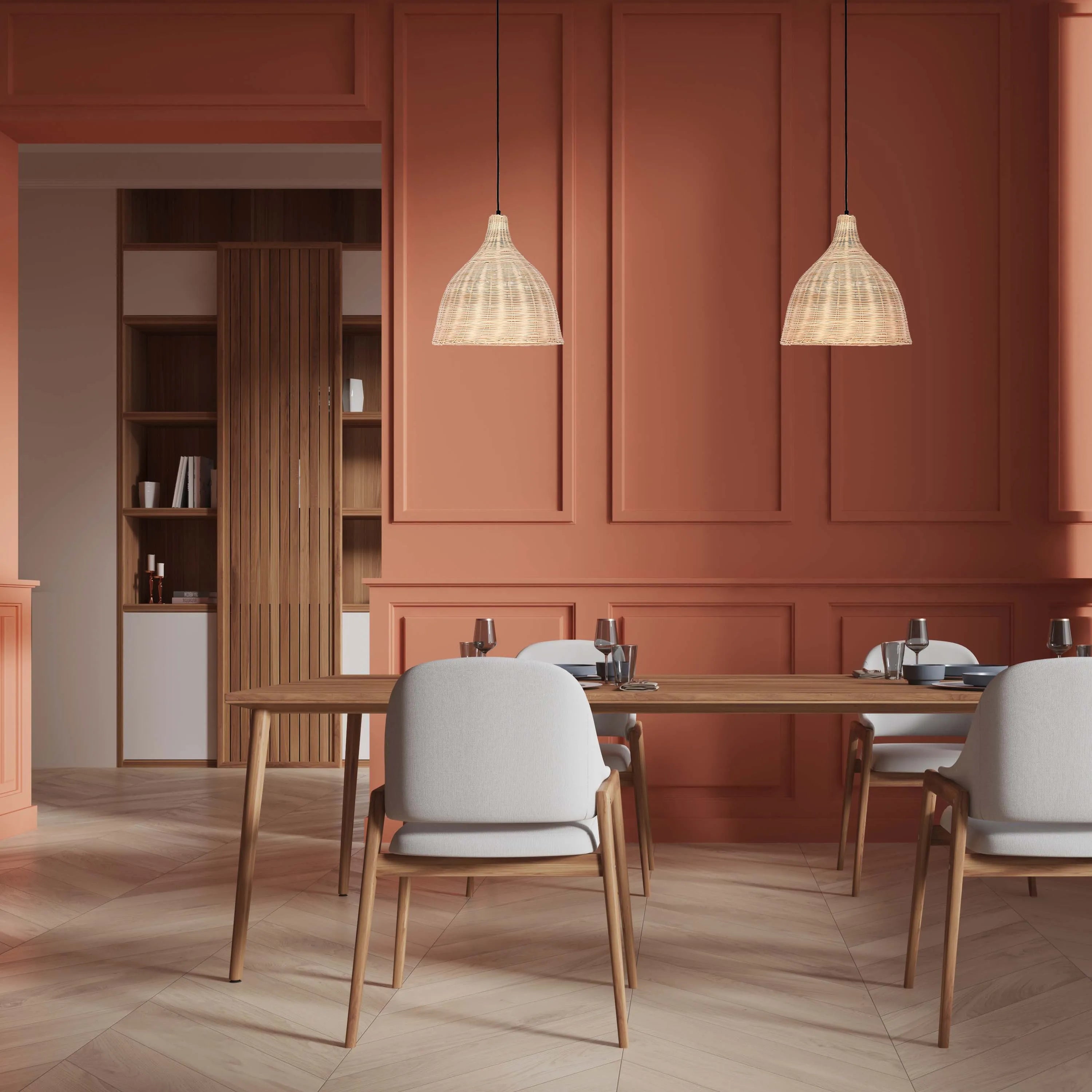 A modern dining area, lit by two woven pendant lights hanging above the wooden table. Warm, inviting and stylish.