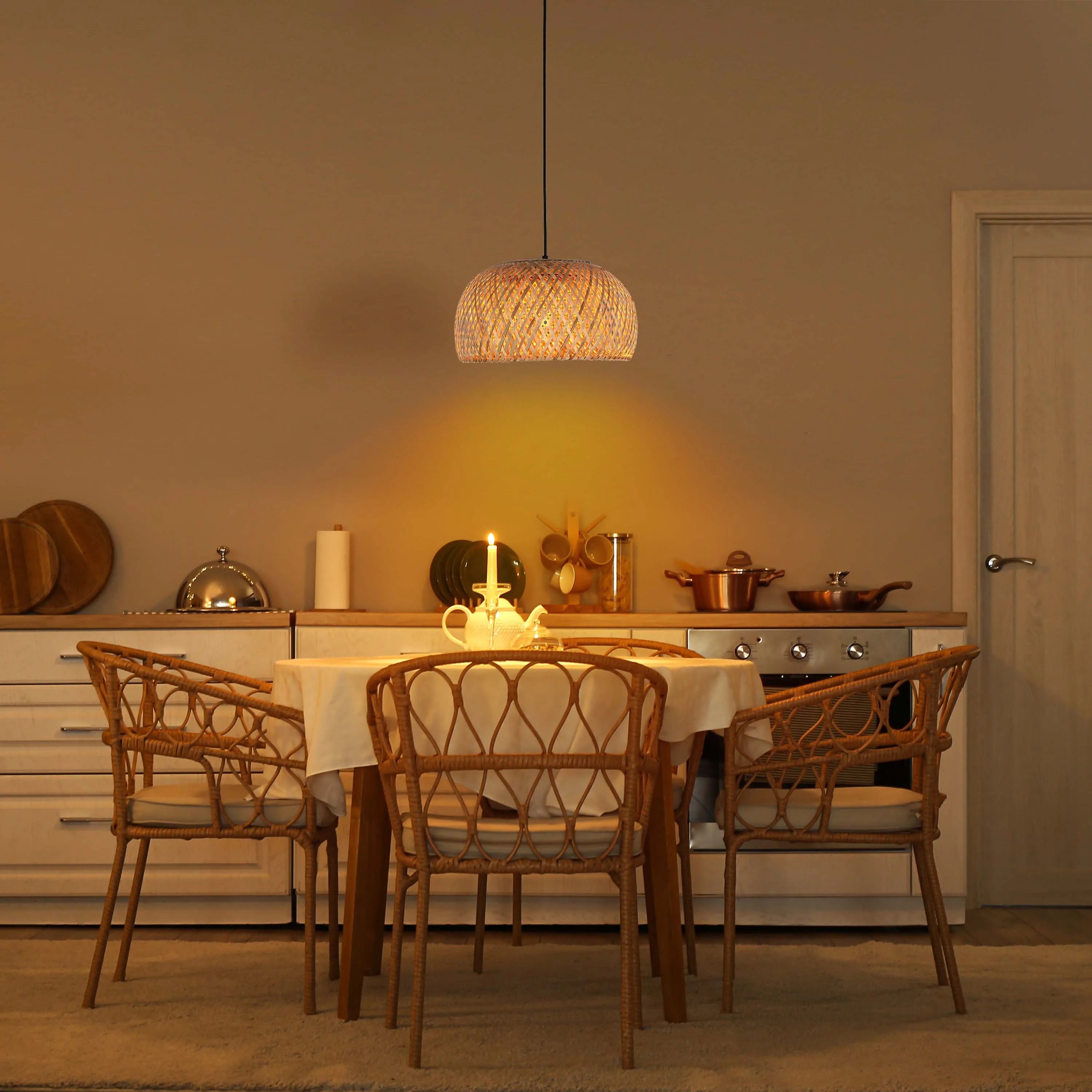 A lit wicker pendant lamp casts a warm glow over a dining table with woven chairs, creating an inviting, rustic atmosphere.
