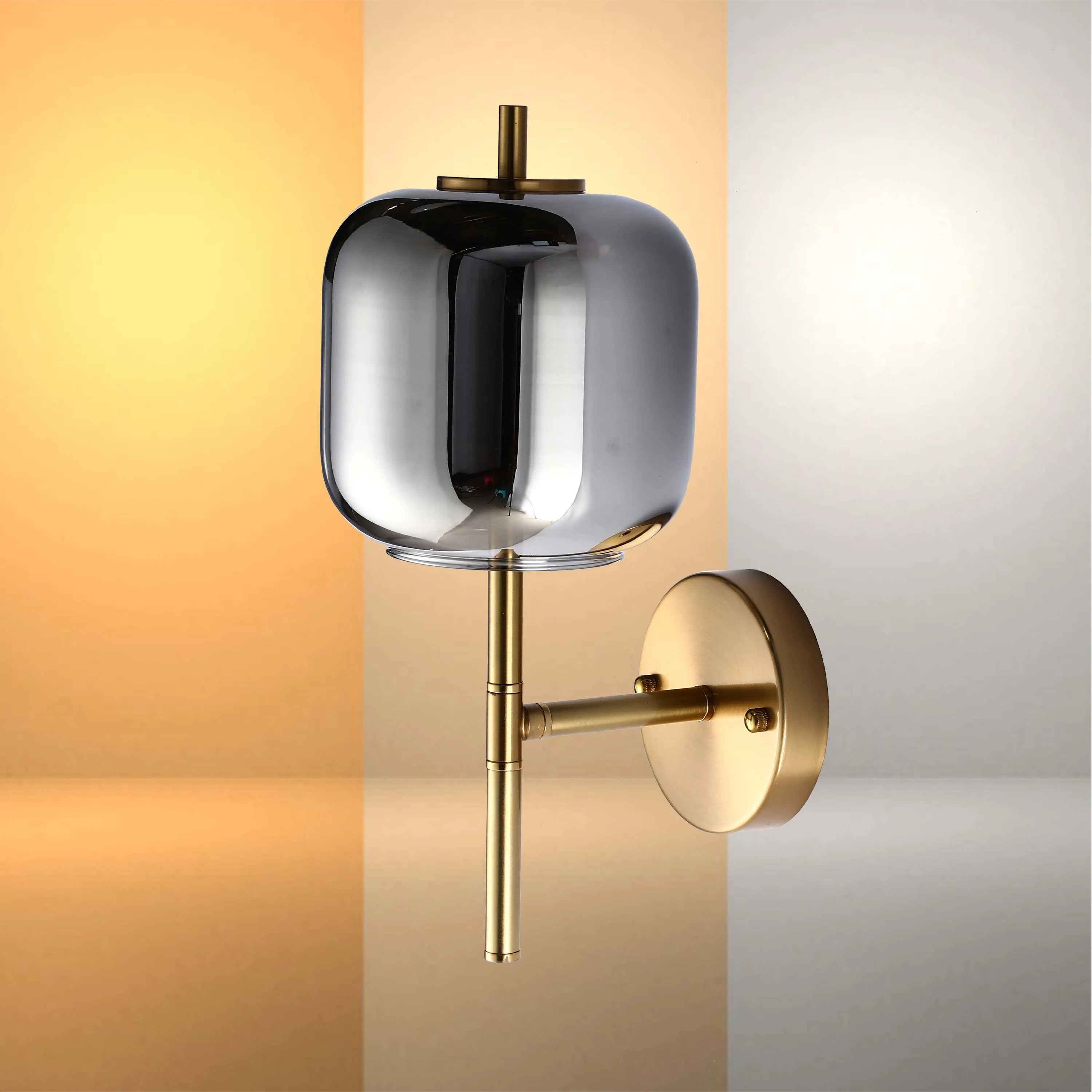 Modern wall light with a smokey glass shade and a brushed brass finish. Adds a touch of elegance to any room.