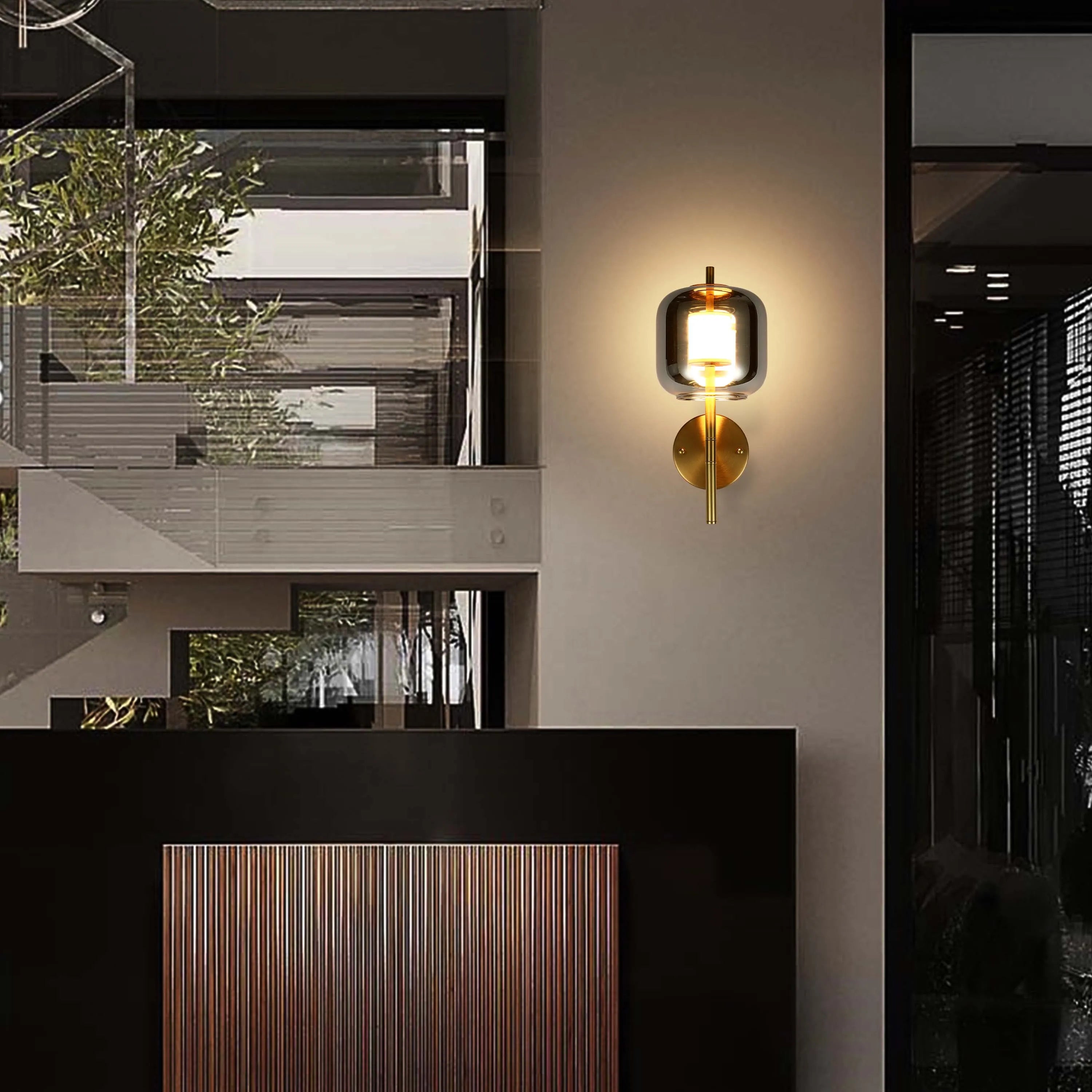 Modern wall light fixture with a glass shade and brass base, adding a touch of elegance to any interior space.