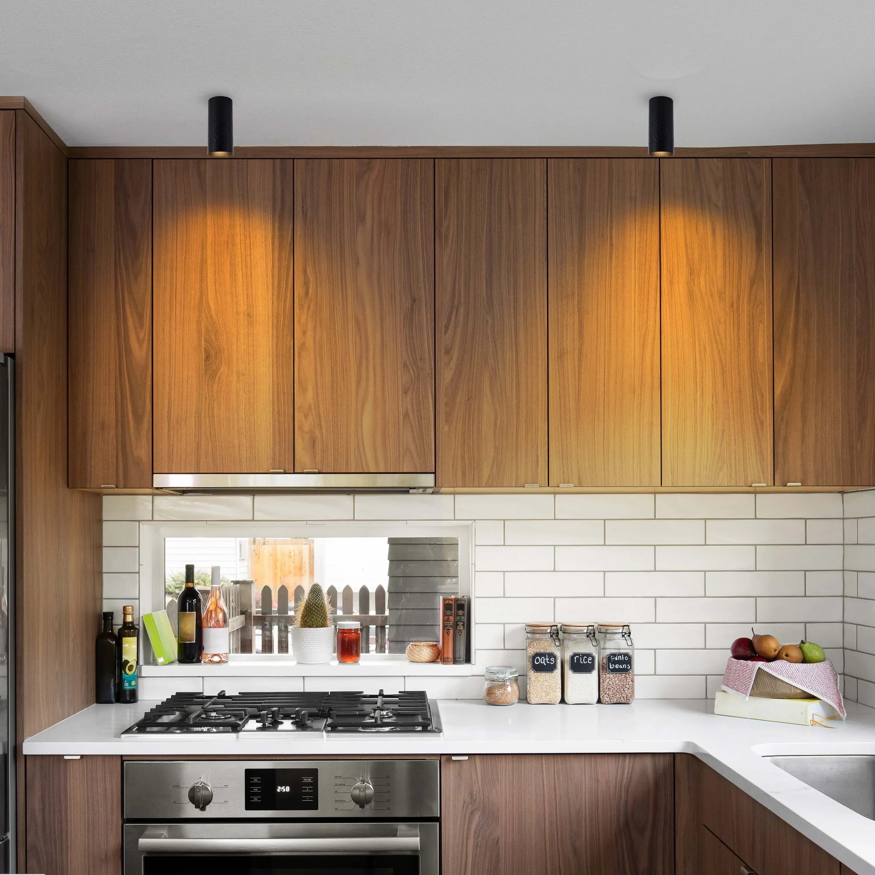 Modern kitchen ceiling lights illuminate wooden cabinets, creating a warm glow in this bright and stylish space.