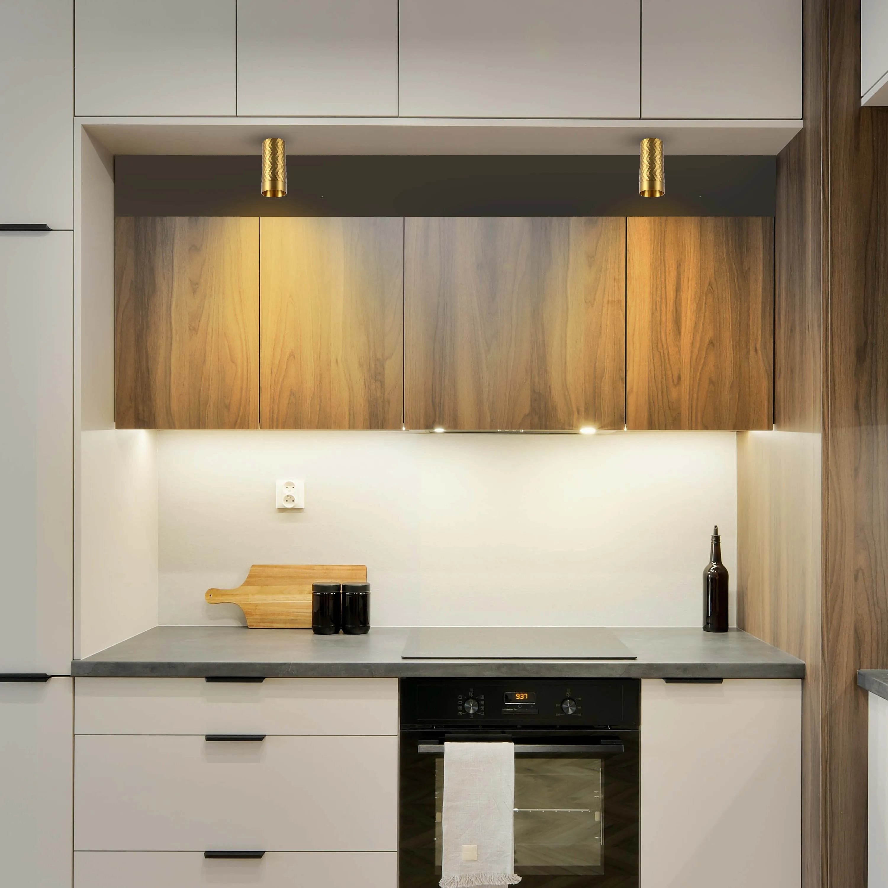 Kitchen lighting featuring downlights above the hob and under-cabinet strip lights. Neutral coloured cabinets and wooden accents.