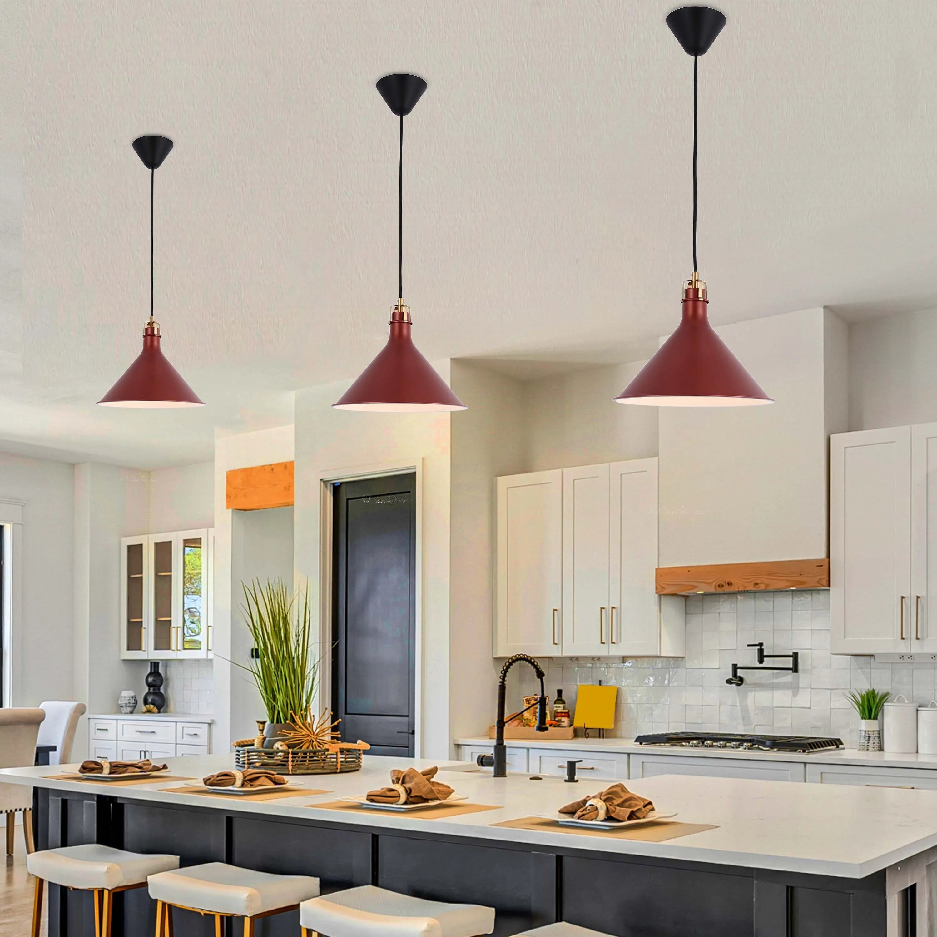 Three maroon pendant lights hang over a kitchen island with black bases and black wires.