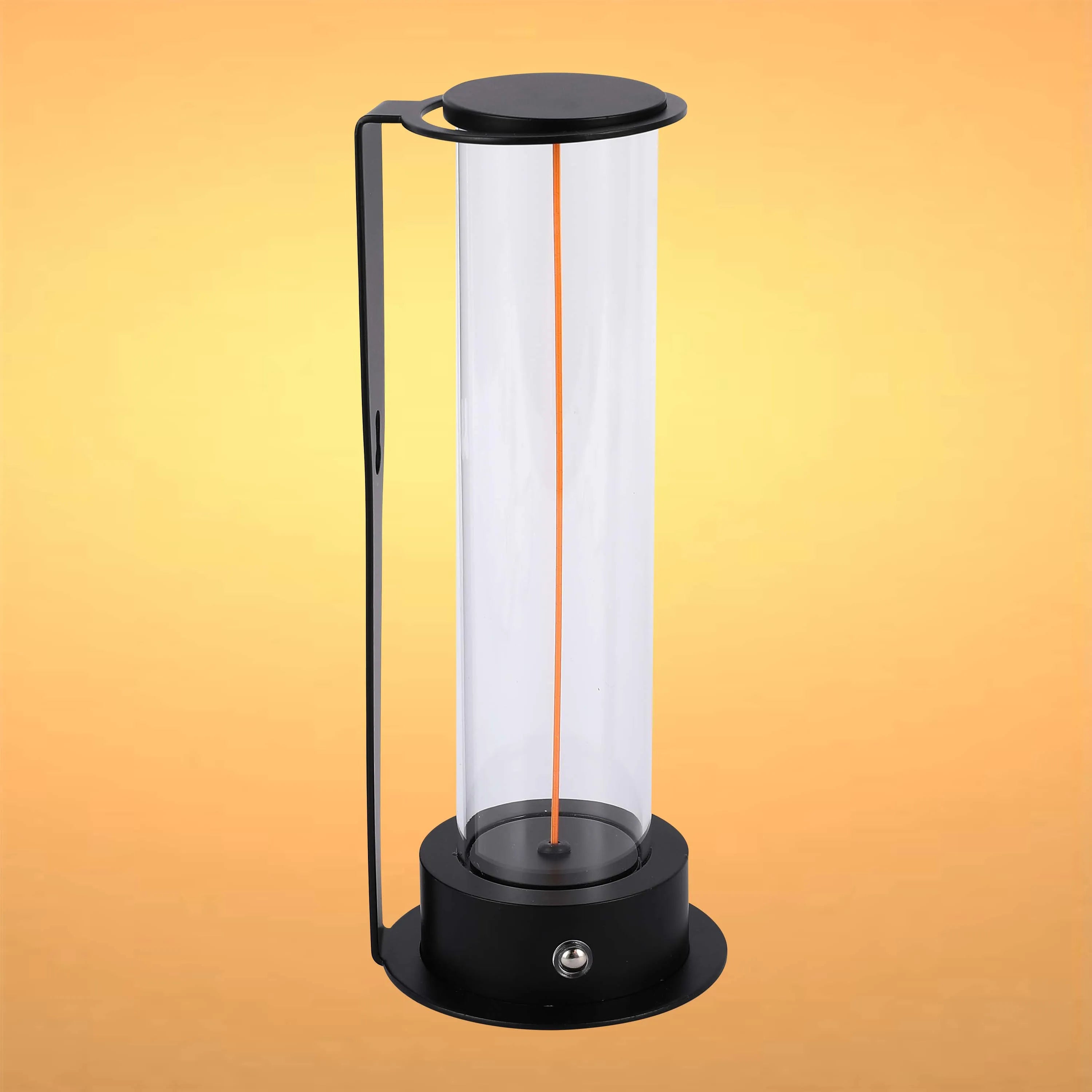 A sleek, black lamp with a cylindrical glass shade and a minimalist design, emitting a warm, inviting light.