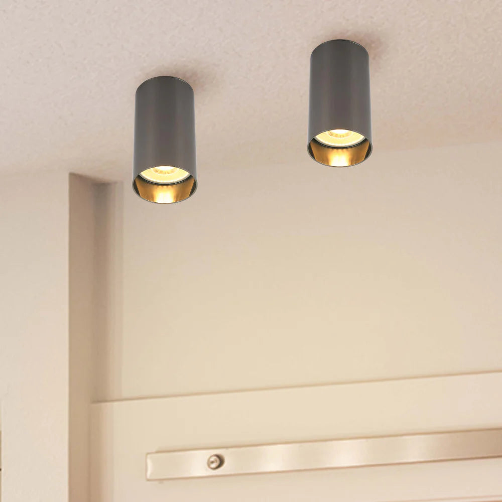 Contemporary grey cylinder spotlights illuminating a modern interior. Provides focused, warm lighting for stylish spaces.