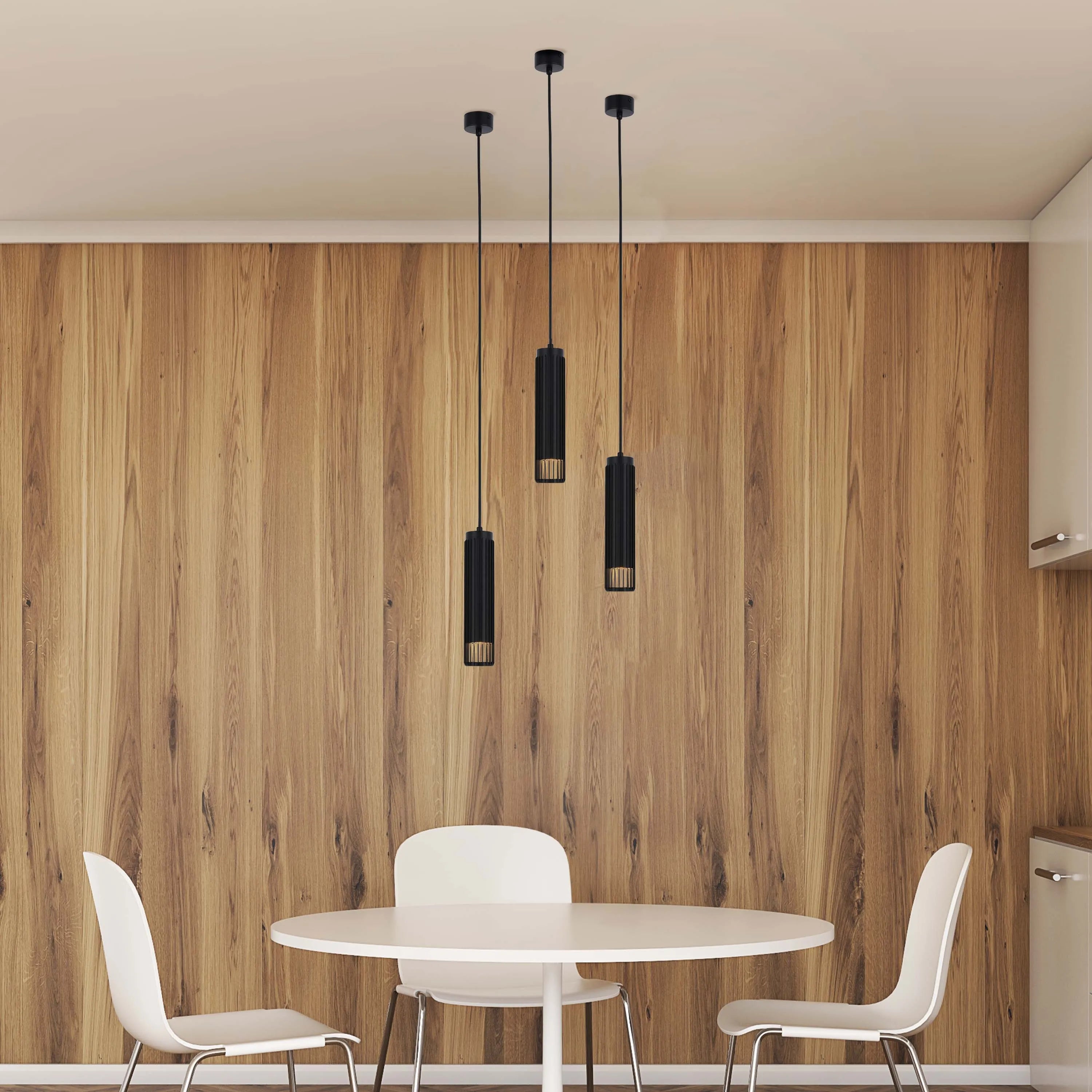 Three pendant lights hang above a white circular table and chairs, creating a modern and stylish dining area.