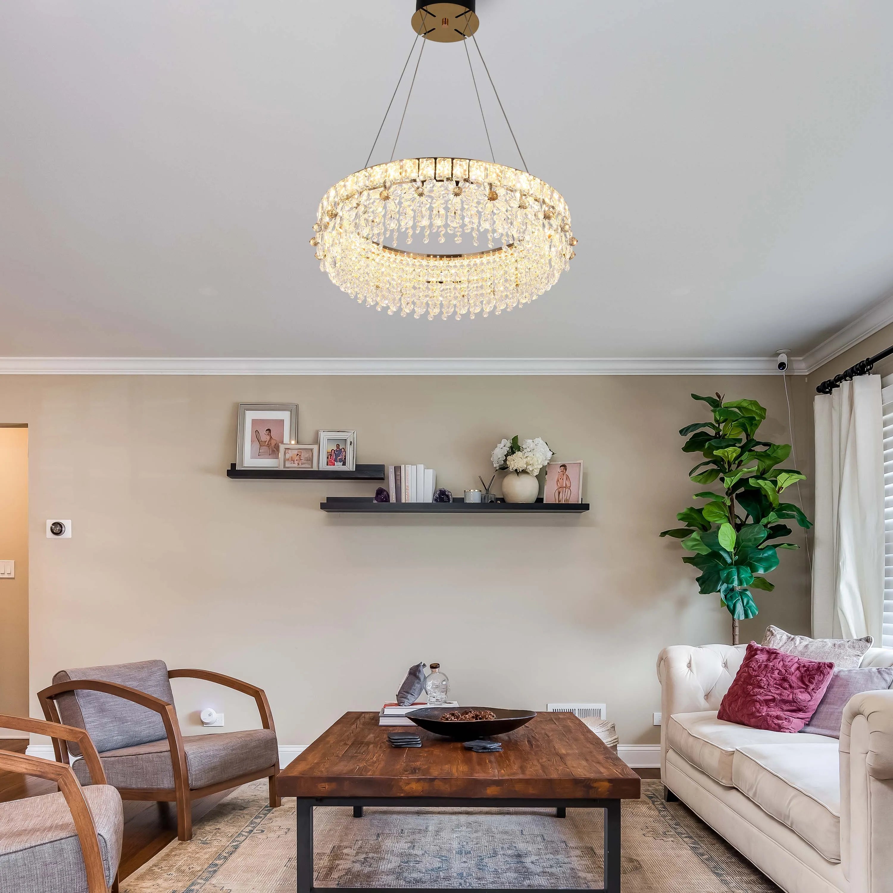 A dazzling, circular crystal chandelier is the focal point, casting a warm glow in this modern living room.