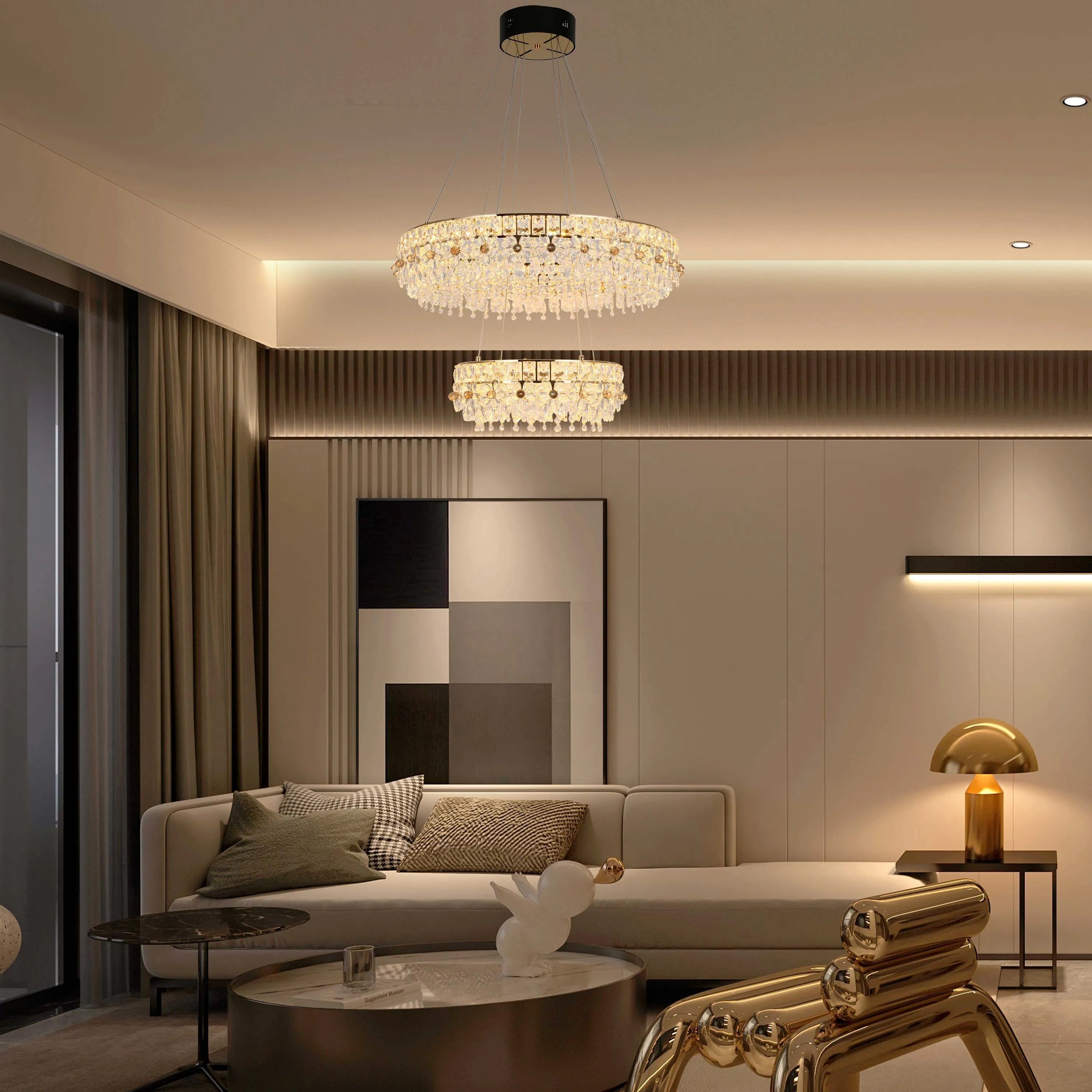 A modern living room showcases two crystal chandeliers, a gold table lamp, and subtle integrated lighting for a warm ambience.