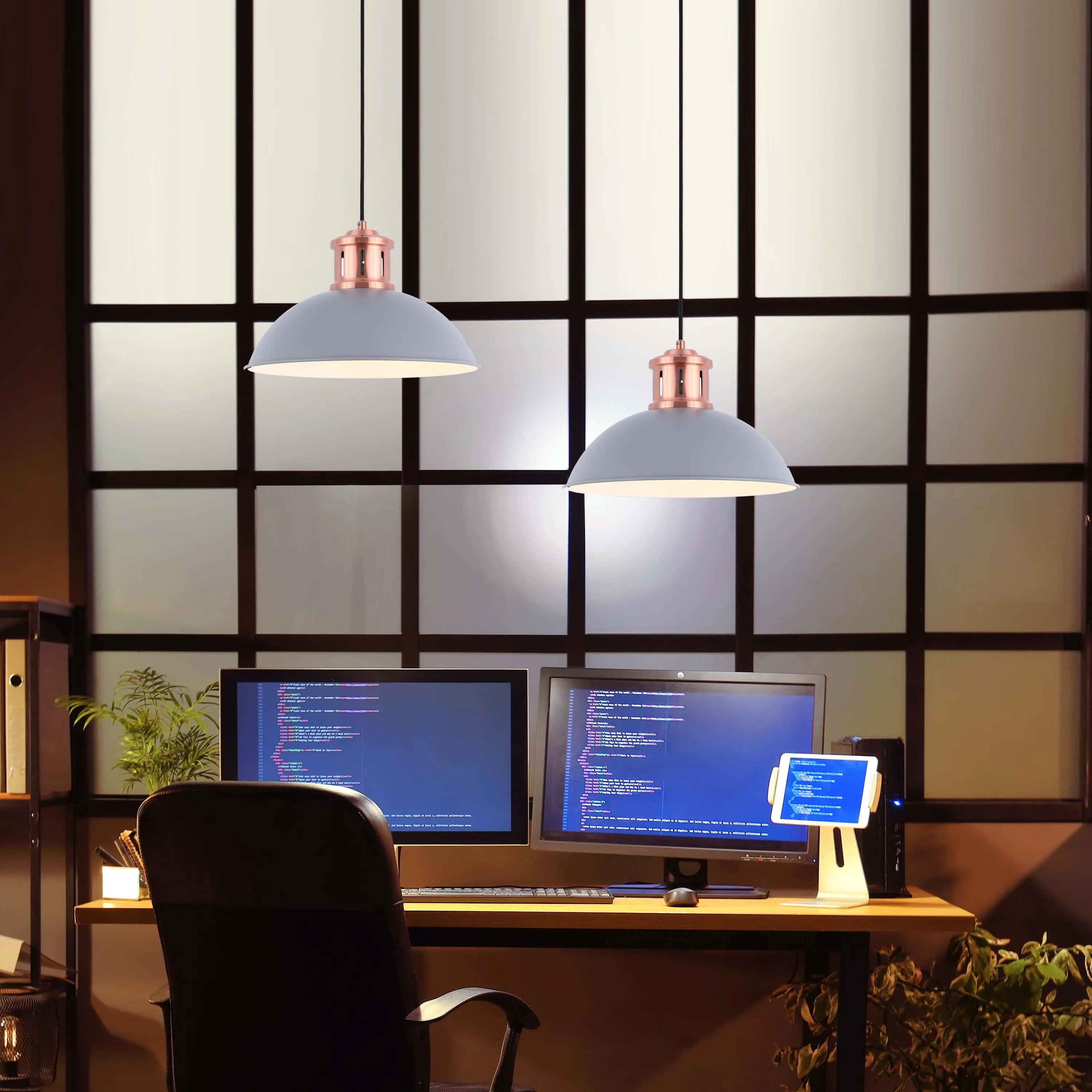 Stylish twin pendant lights illuminate a home office. The lamps feature a copper finish and dome shades, creating a warm atmosphere.