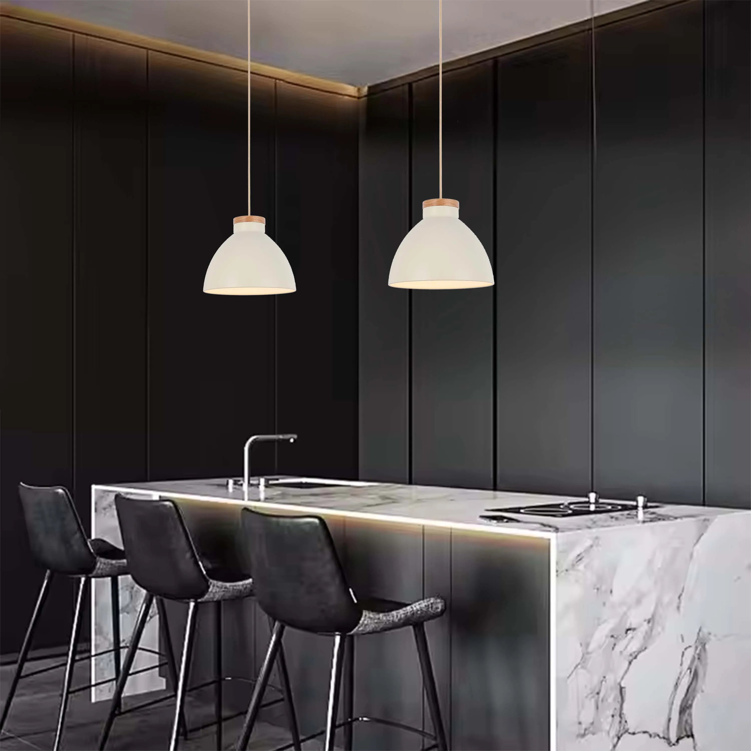 A pair of stylish, modern pendant lights illuminate this sleek kitchen, adding a warm glow to the marble countertop.