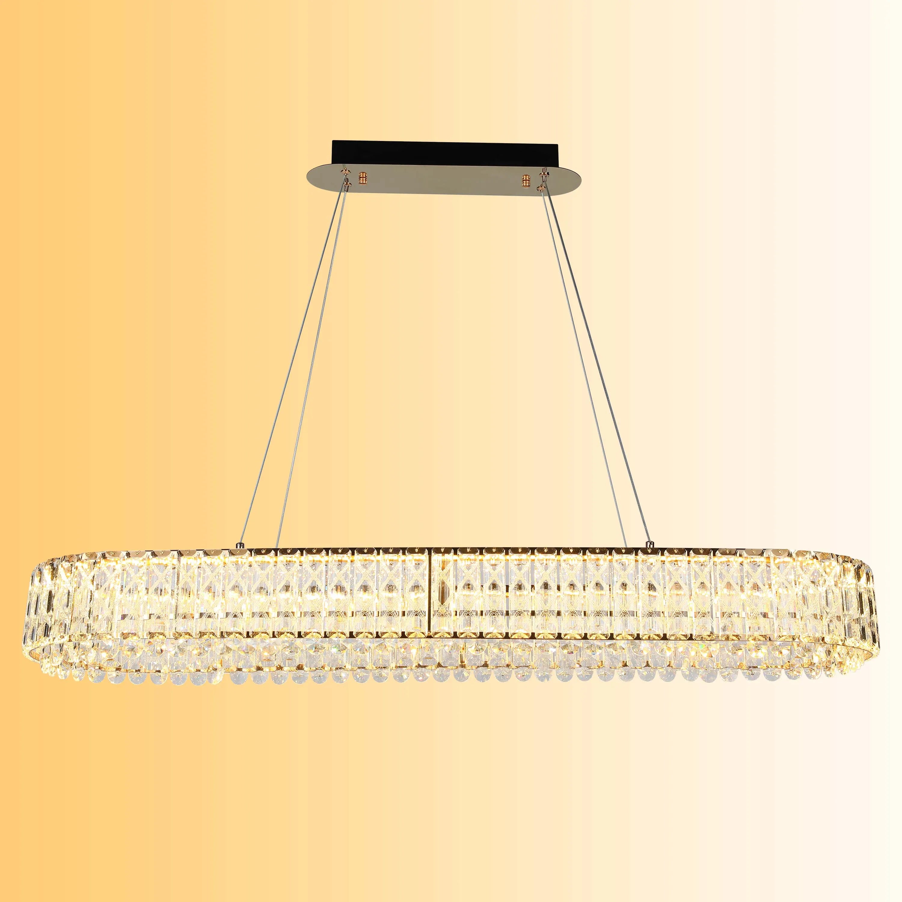 A luxurious, crystal-embellished, oval chandelier provides a warm and elegant light.