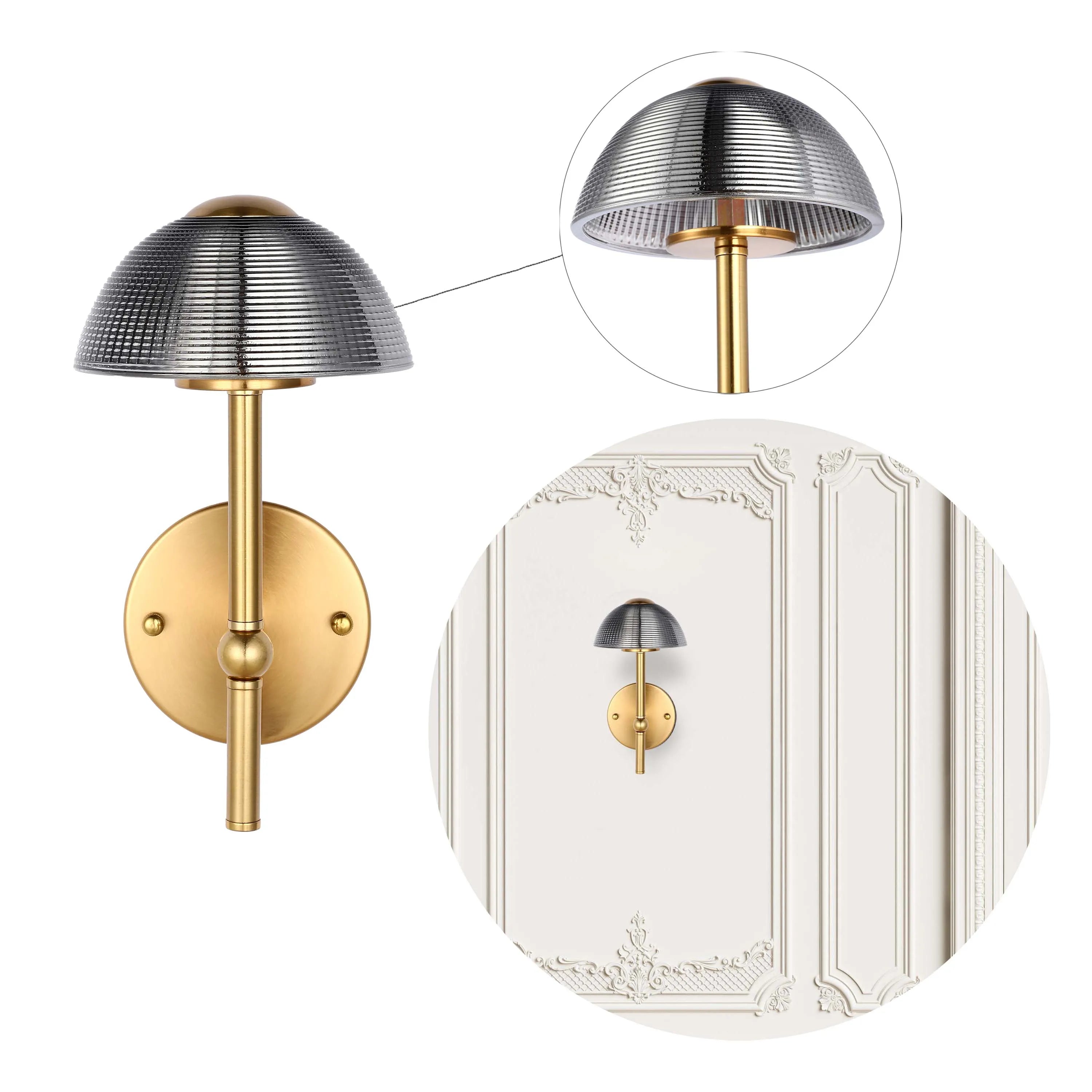 A polished brass wall light with a fluted smoke glass shade, displayed in detail and in situ on a panelled wall.