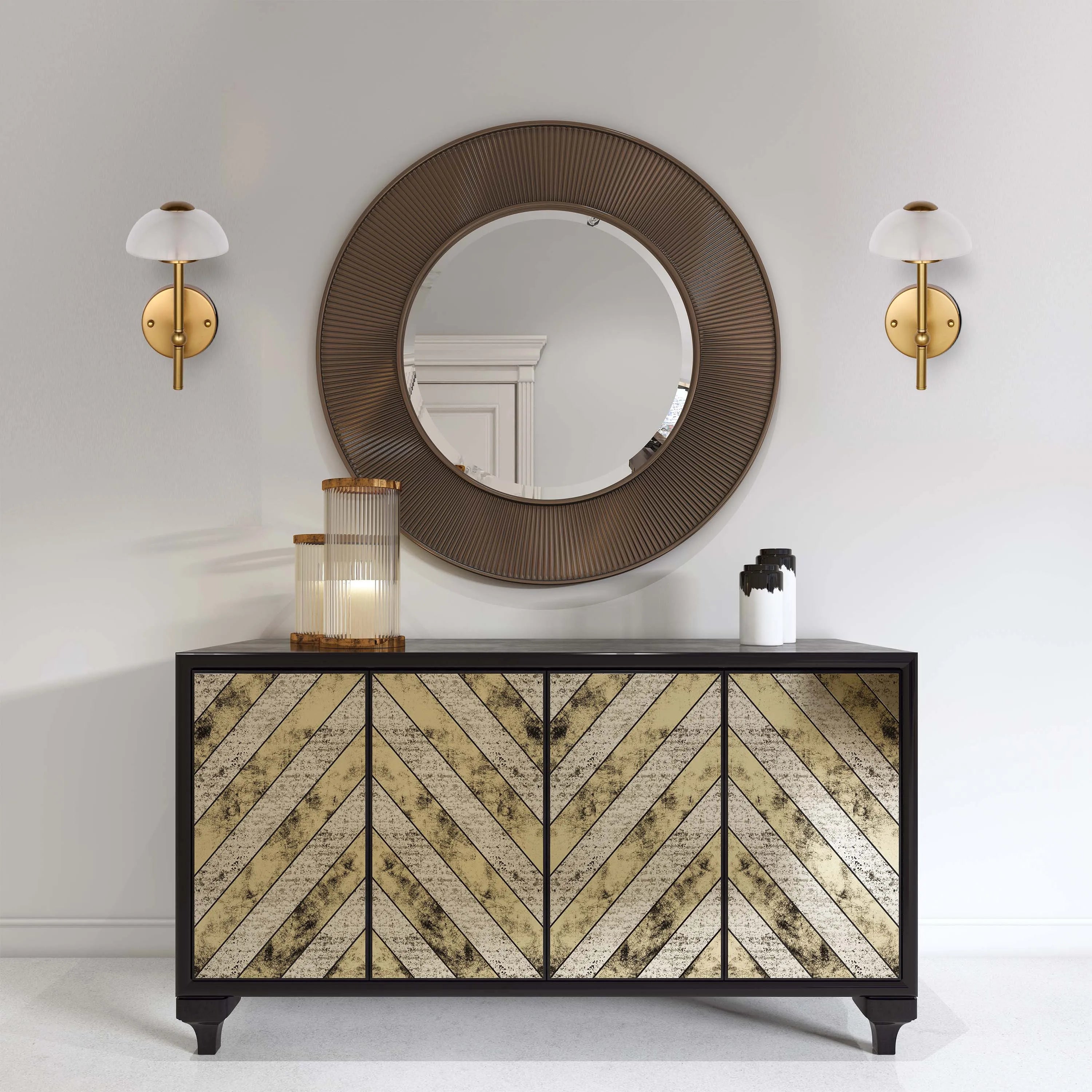 A sideboard displaying modern wall lights and a glass candle holder. The lamps are brass with white shades.