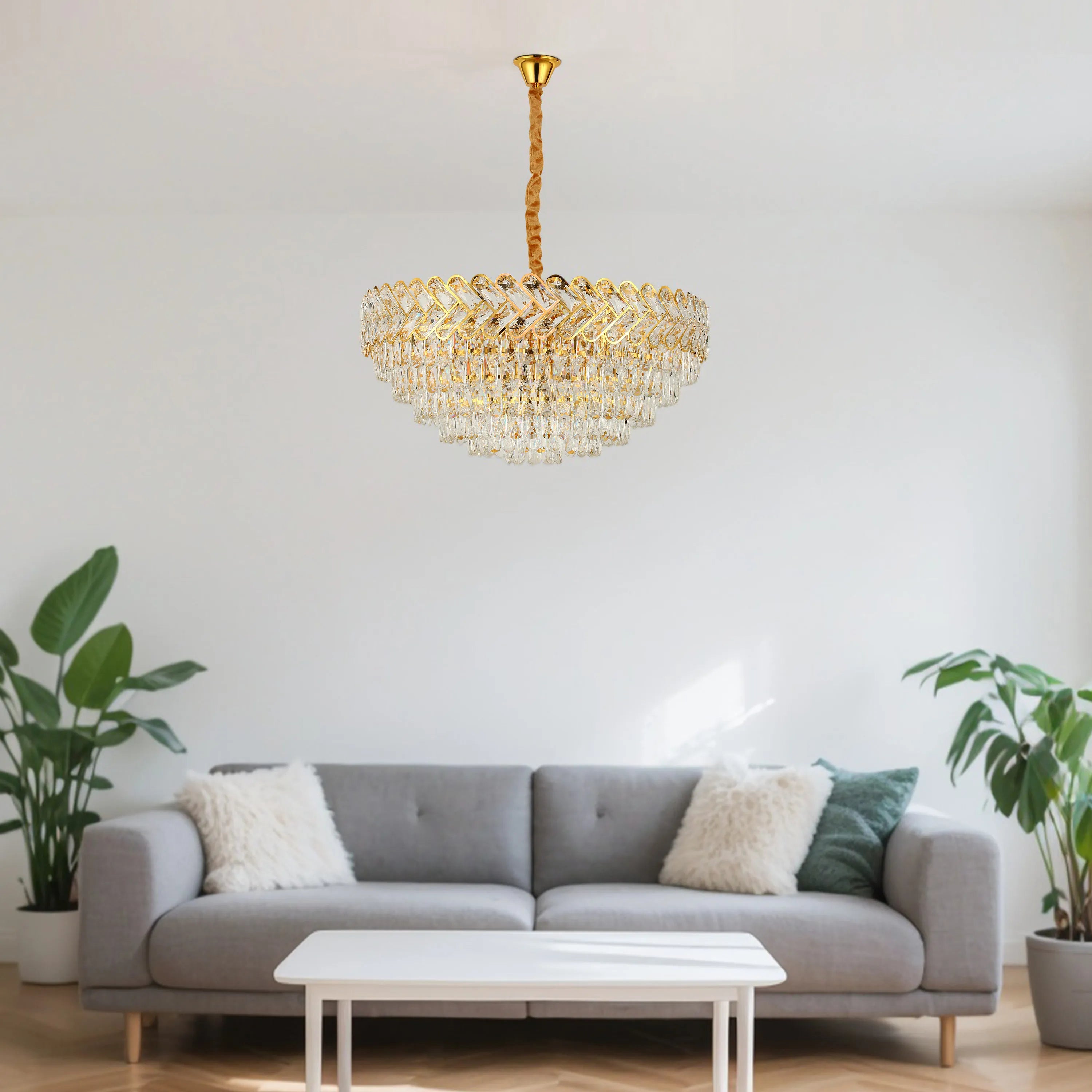 A gold chandelier with crystal embellishments provides stylish ambient lighting in a neutral toned living room.