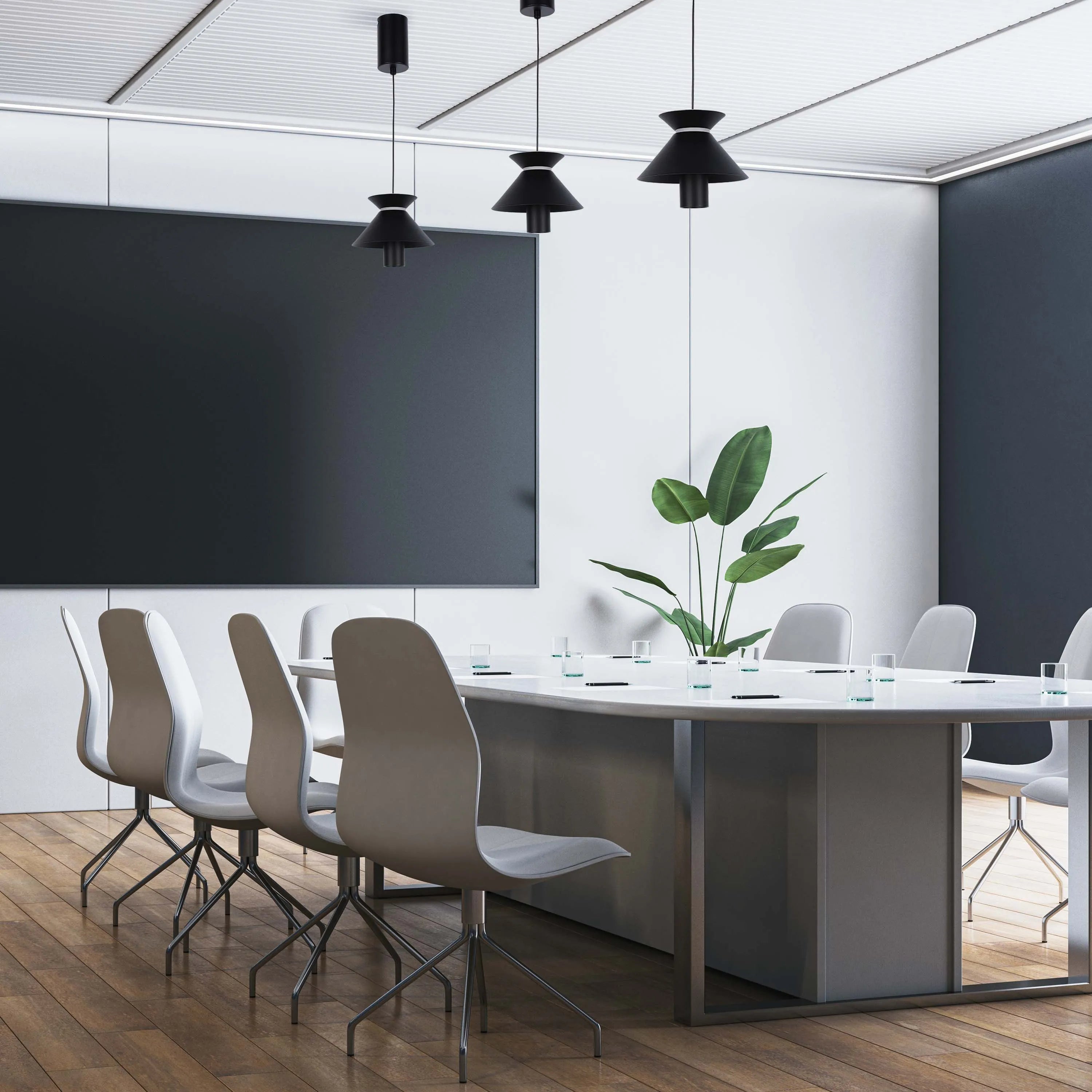 Three black pendant lights hang above a modern conference table in a bright, contemporary meeting room, providing focused illumination.