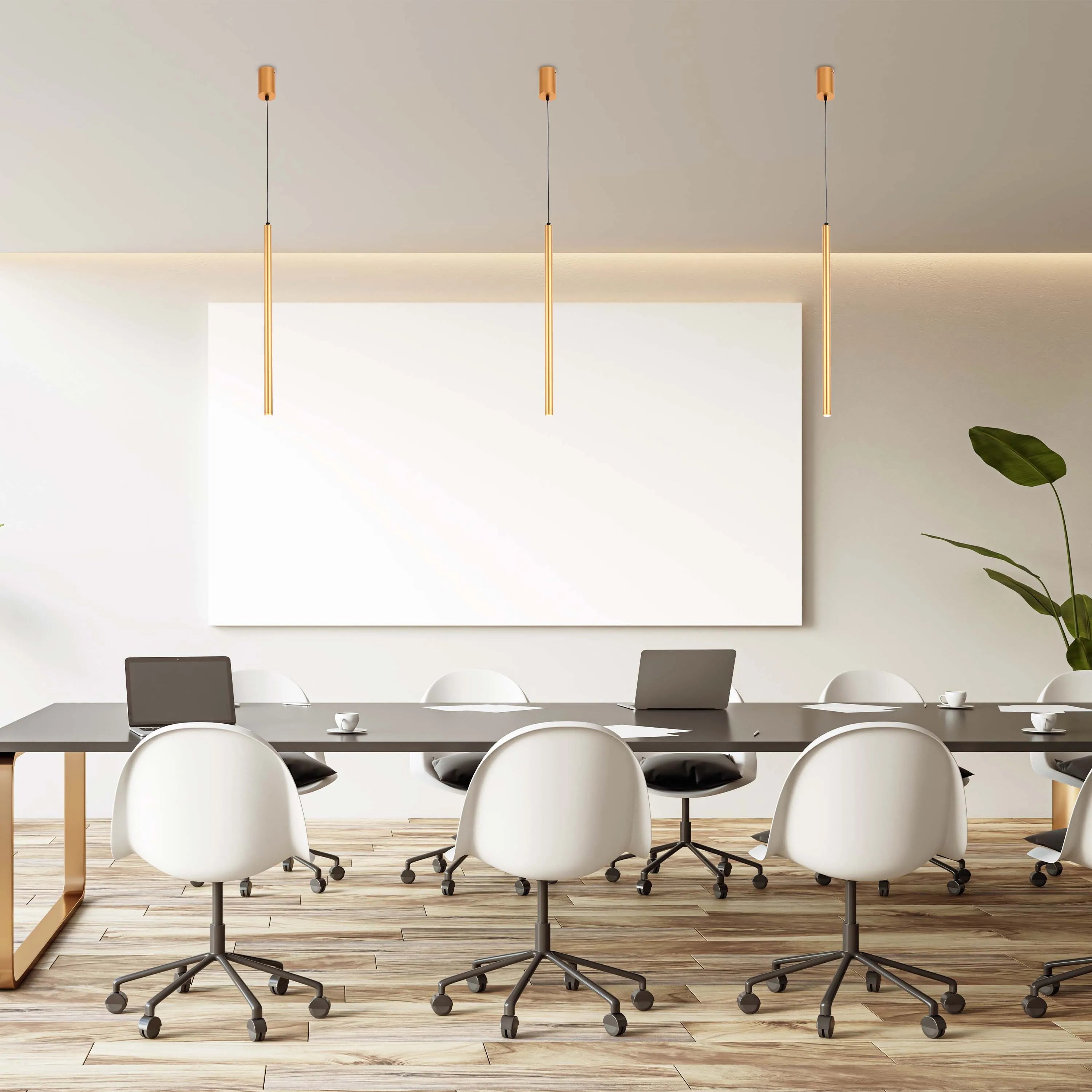 Modern, sleek lighting fixtures hang above a conference table in this bright, open-plan office space.