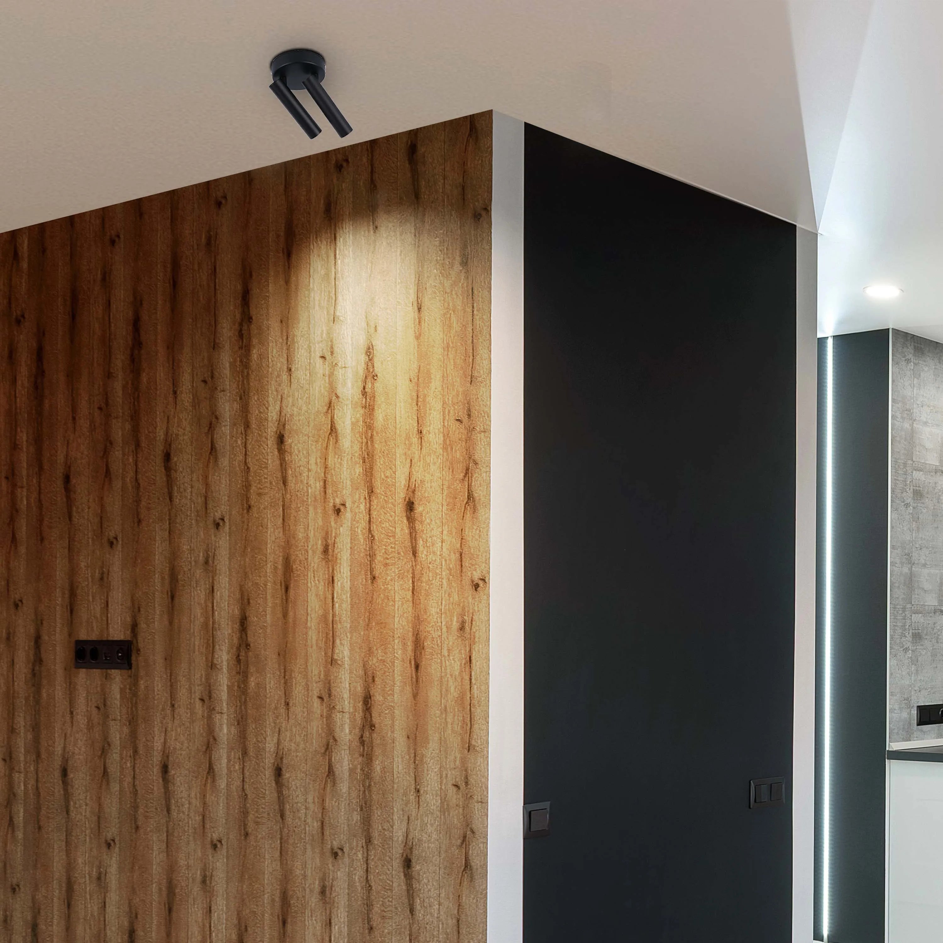 Modern interior lighting featuring a sleek, black track spotlight and ambient LED strip lighting highlighting architectural features.