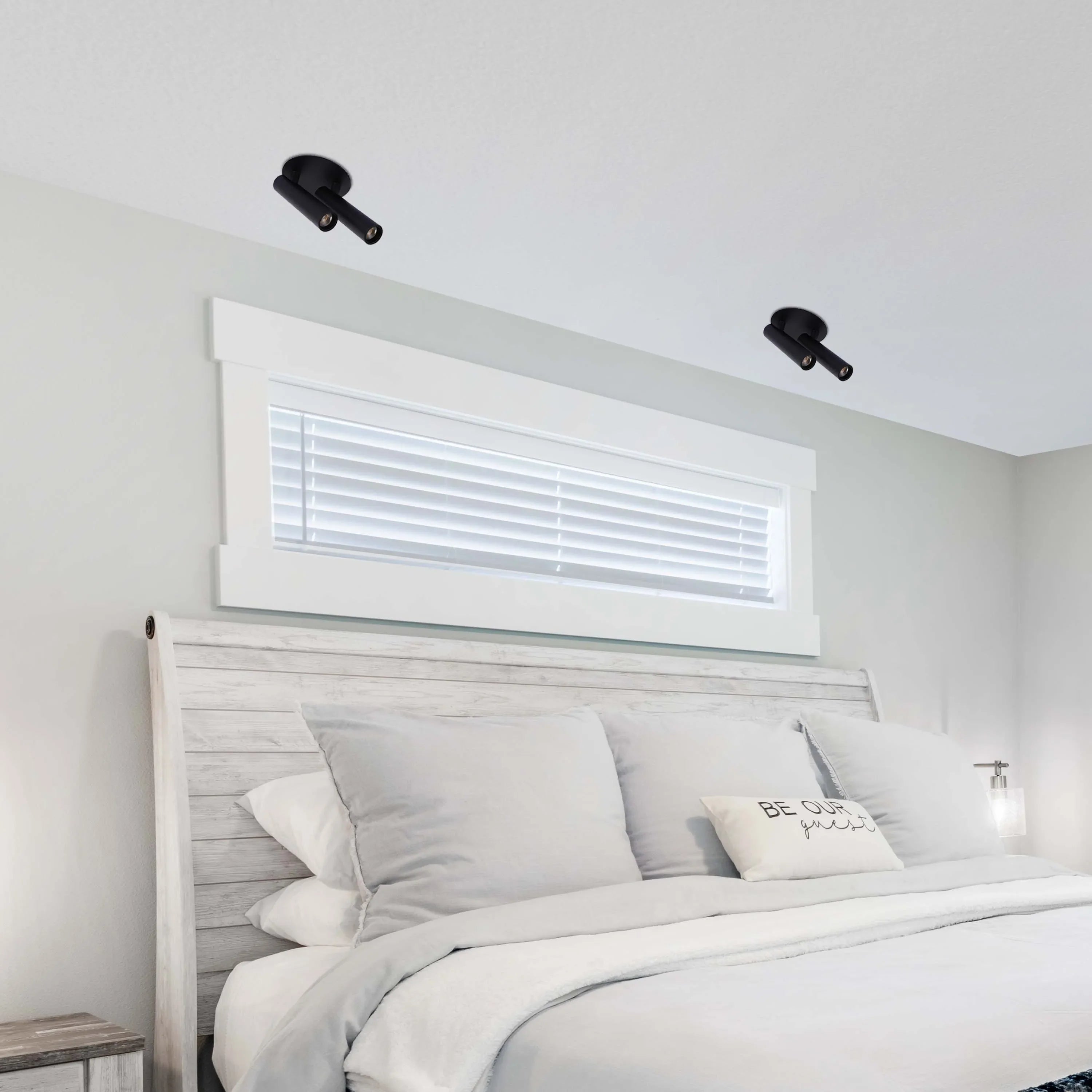 Two dual-bulb, matte black spotlights provide focused illumination from above, perfect for a modern bedroom lighting scheme.