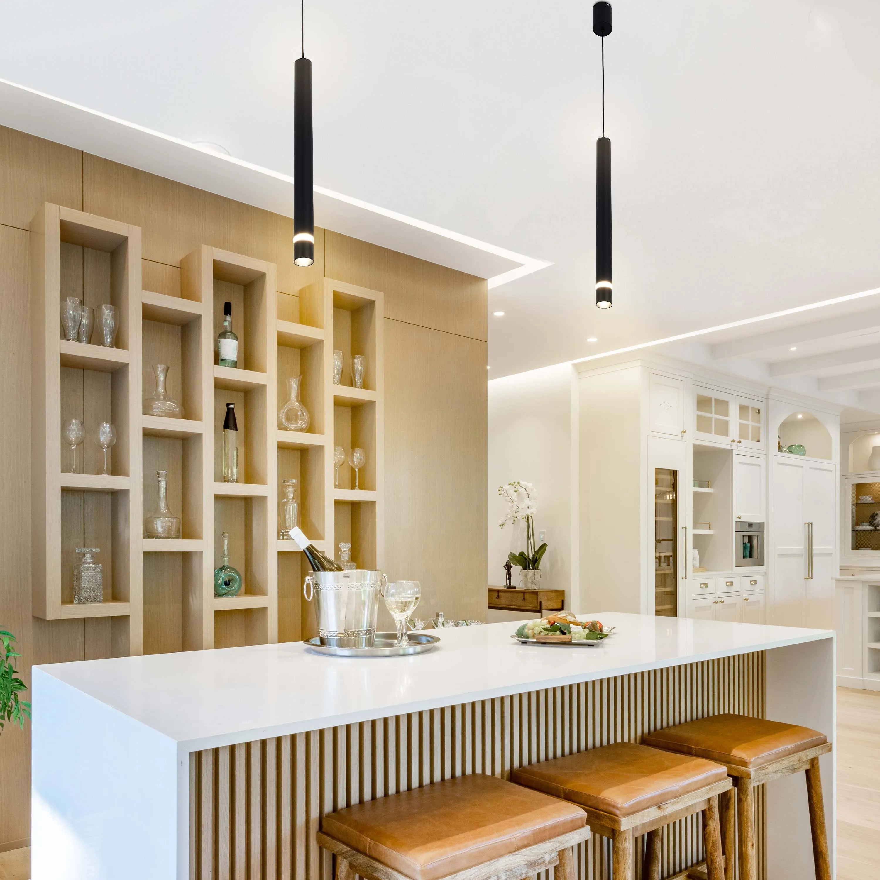 Contemporary kitchen lighting features sleek, black pendant lights that illuminate a stylish island and bar area.