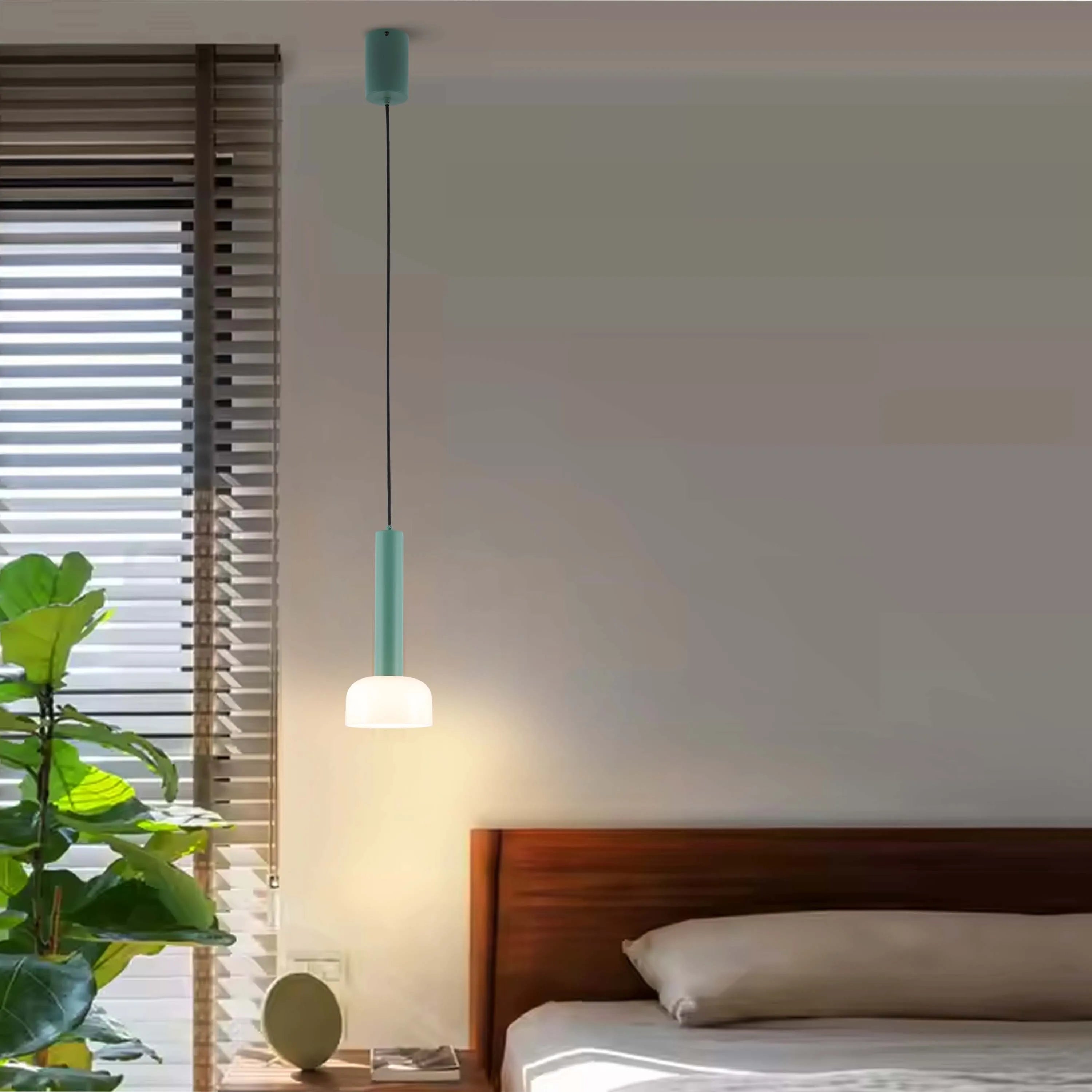 A stylish, pastel green pendant light softly illuminates a modern bedroom. A striking design statement for any home.