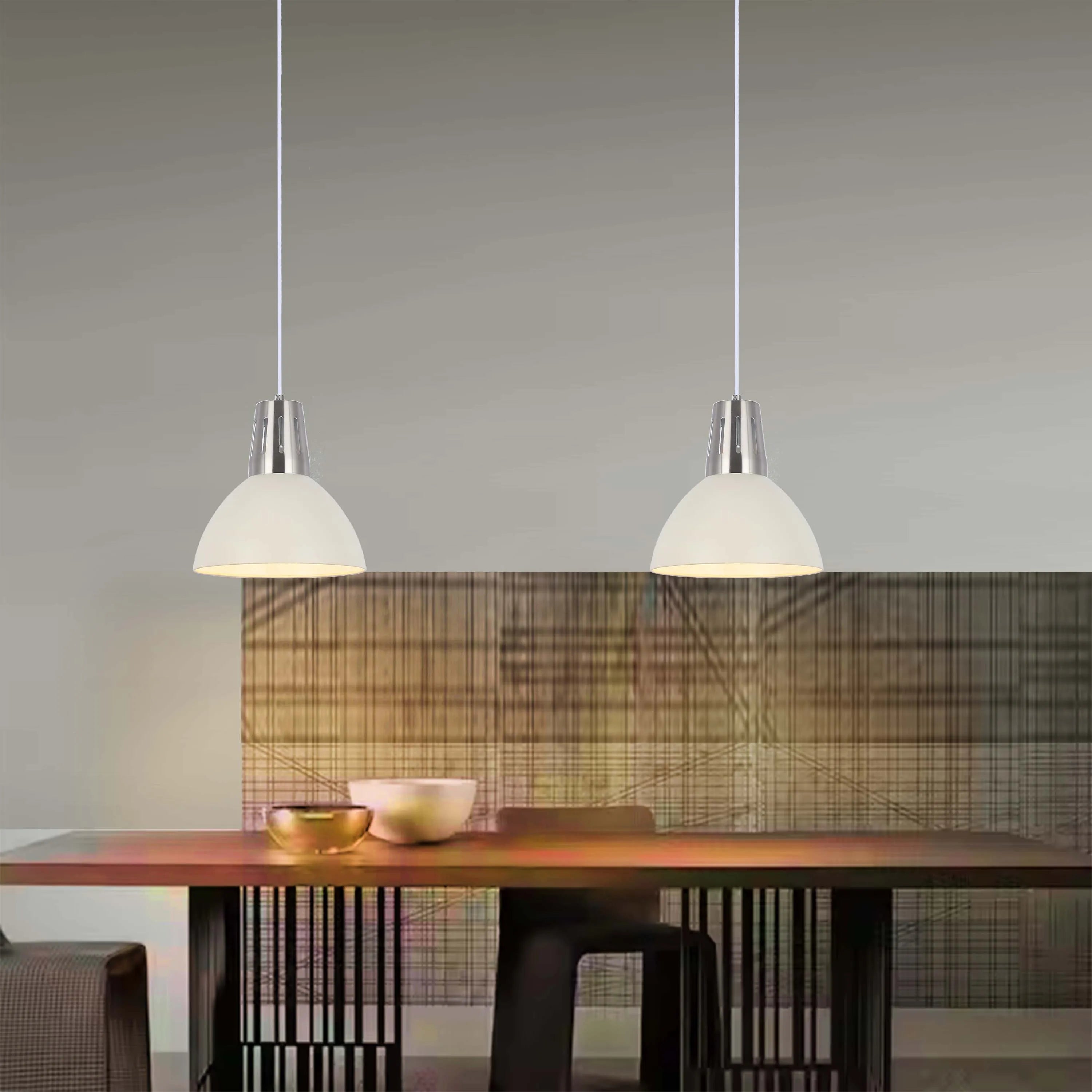 Two pendant lights with domed shades hang over a dining table, creating a warm and inviting atmosphere.