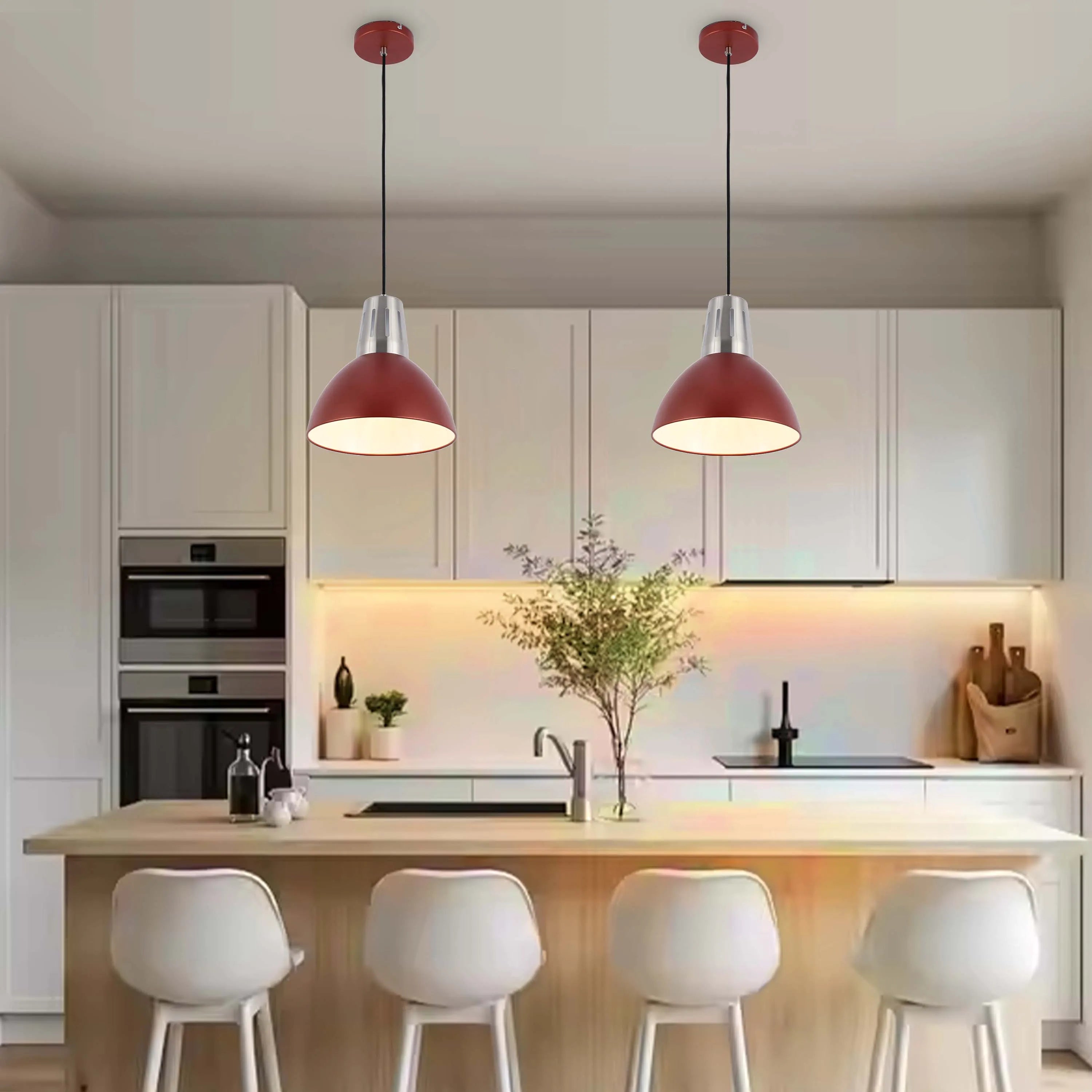 Two red pendant lights hang above a kitchen island, illuminating the modern space with a warm glow.