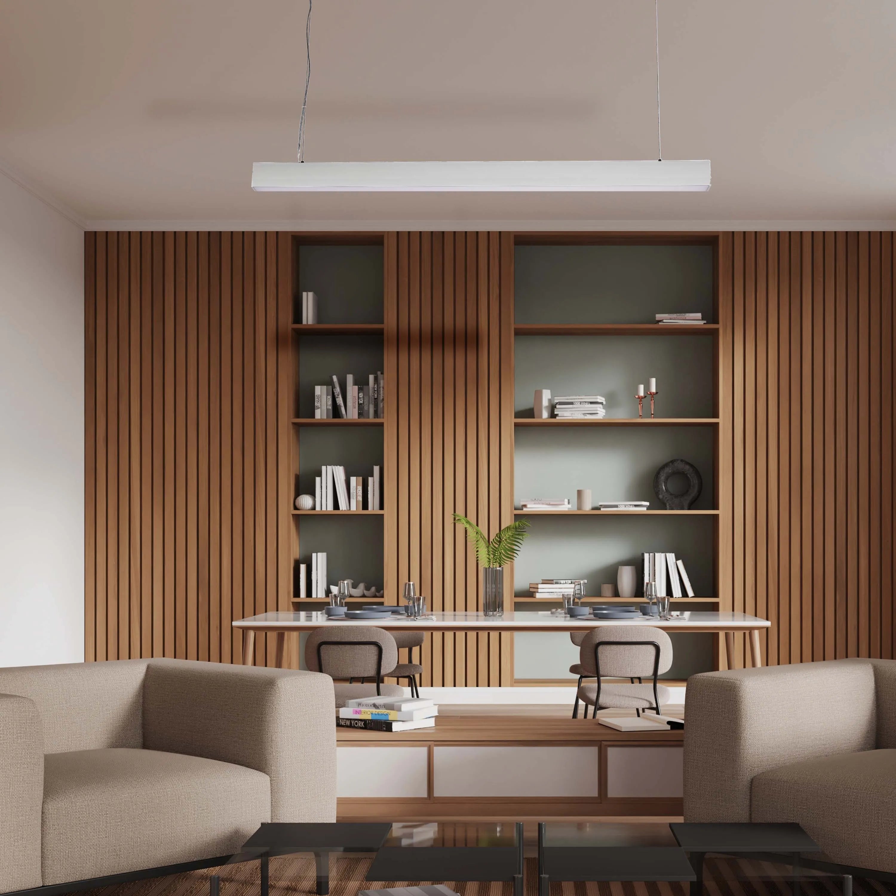 A modern, linear pendant light hangs over a bright, contemporary office space, providing clean, efficient task lighting.