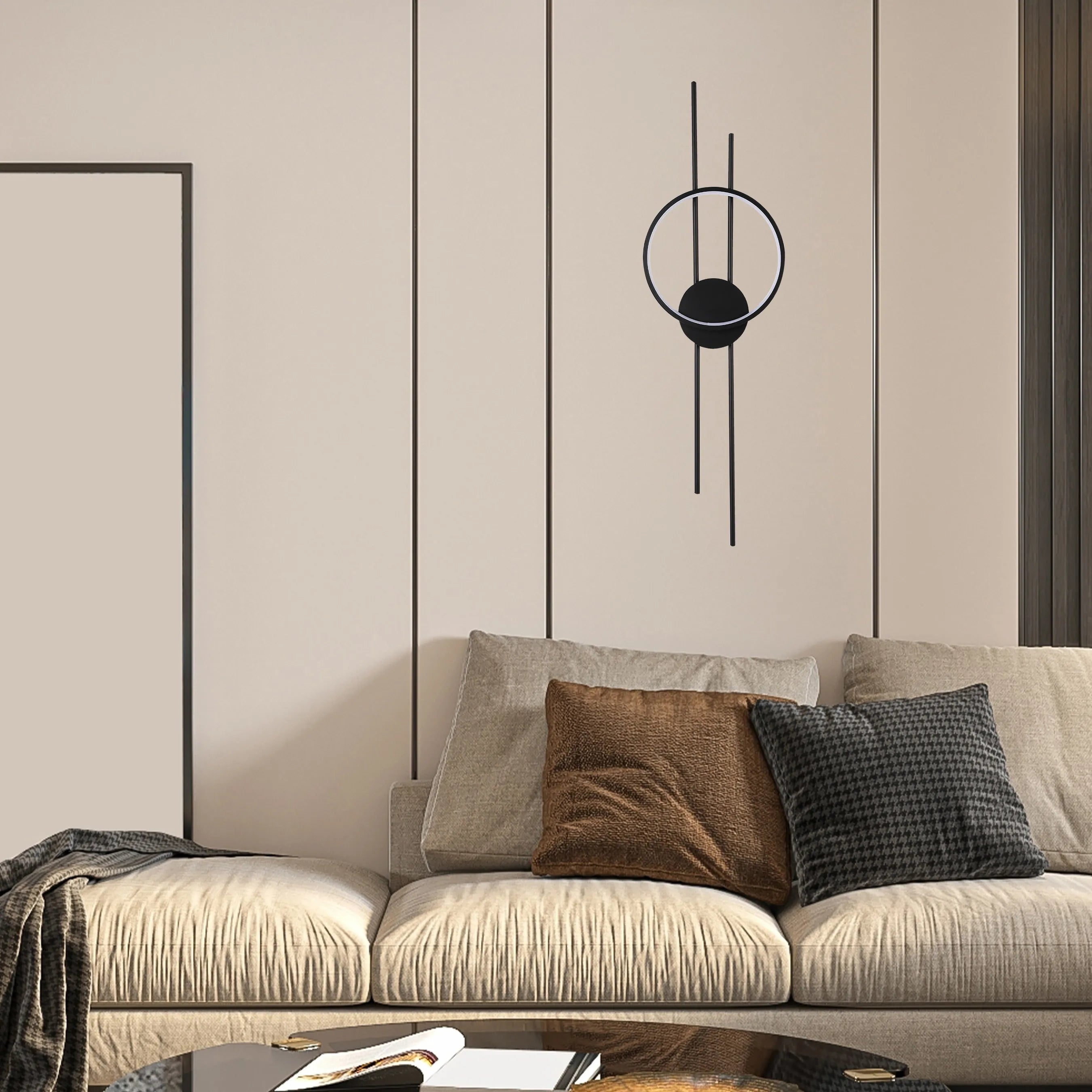 Modern wall light with matte black finish and circular design, casting a soft, ambient glow on the beige wall.