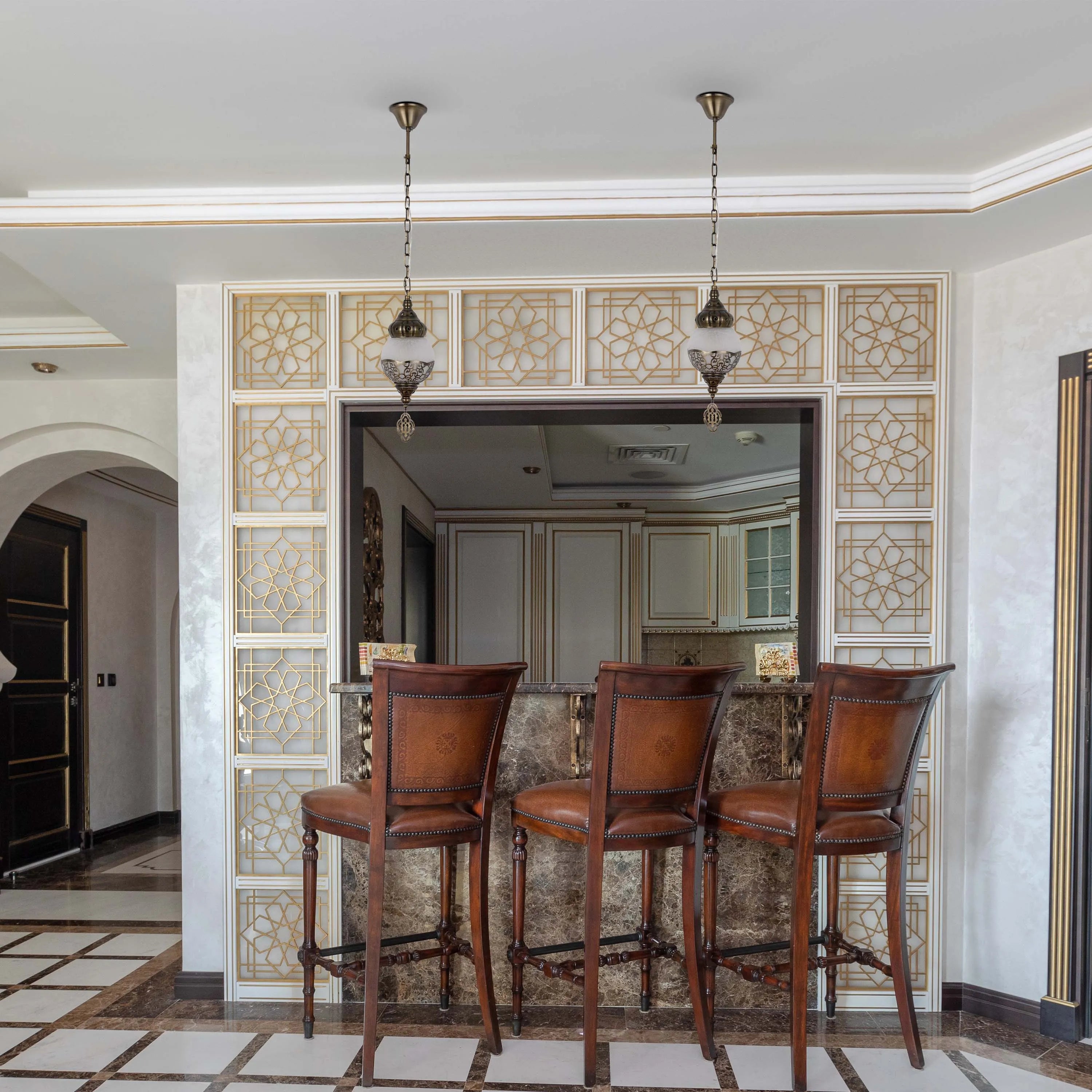 A pair of ornate pendant lights hang above the bar, illuminating the space with warm, ambient light.