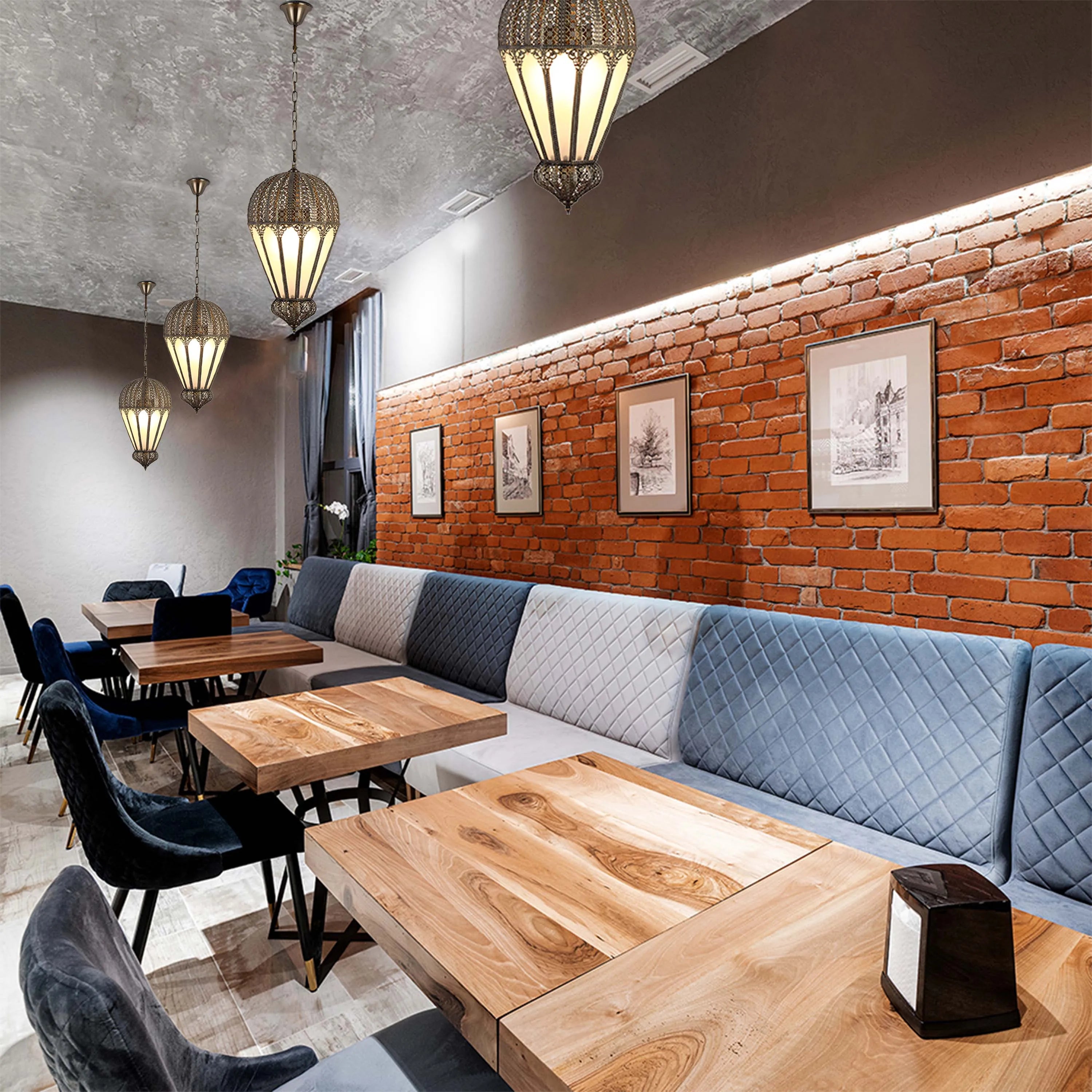 A variety of stylish pendant lights hang above wooden tables in a restaurant, creating a warm and inviting ambience.