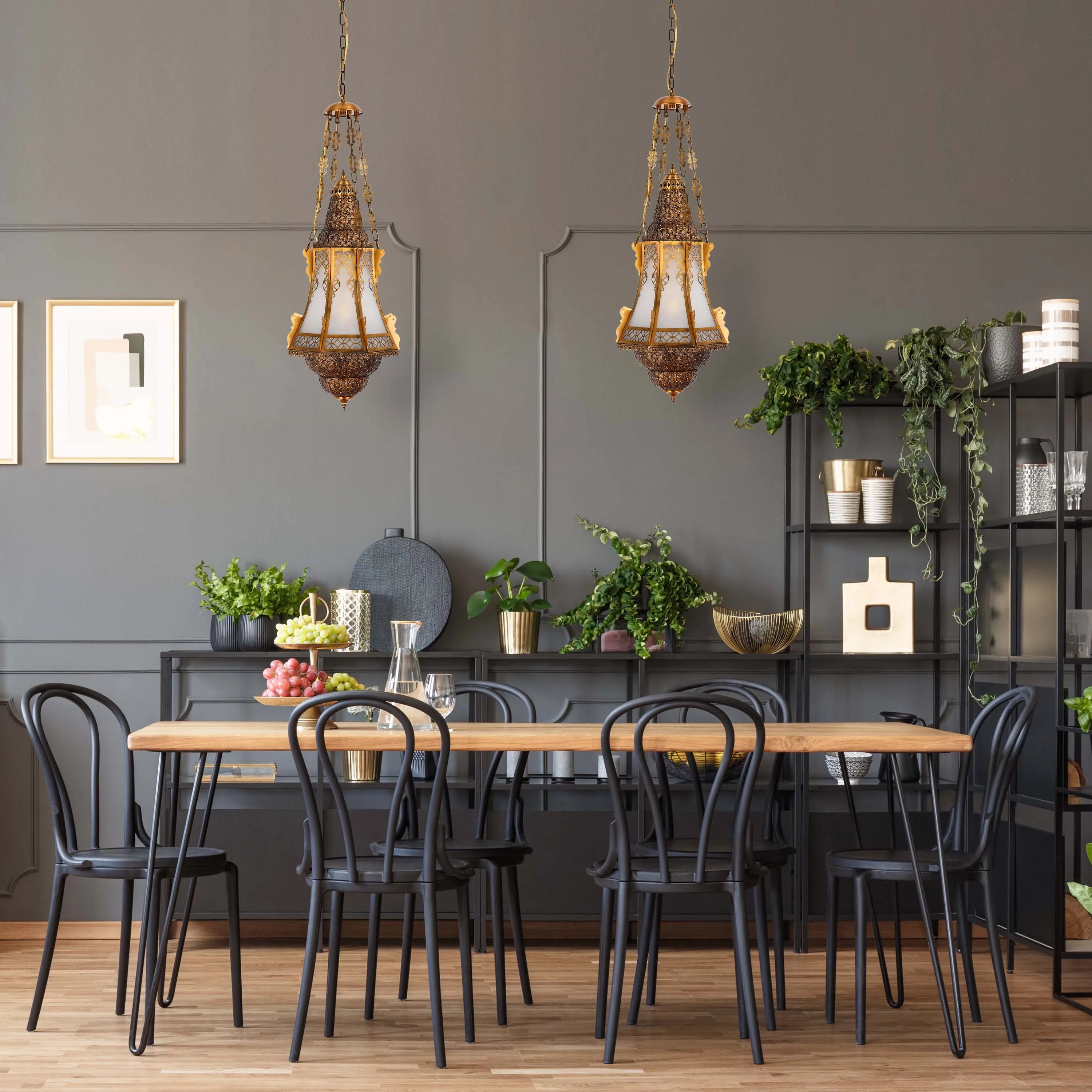 Two ornate, pendant lights hang above a dining table, casting a warm glow. The fixtures feature decorative metalwork and diffused shades.