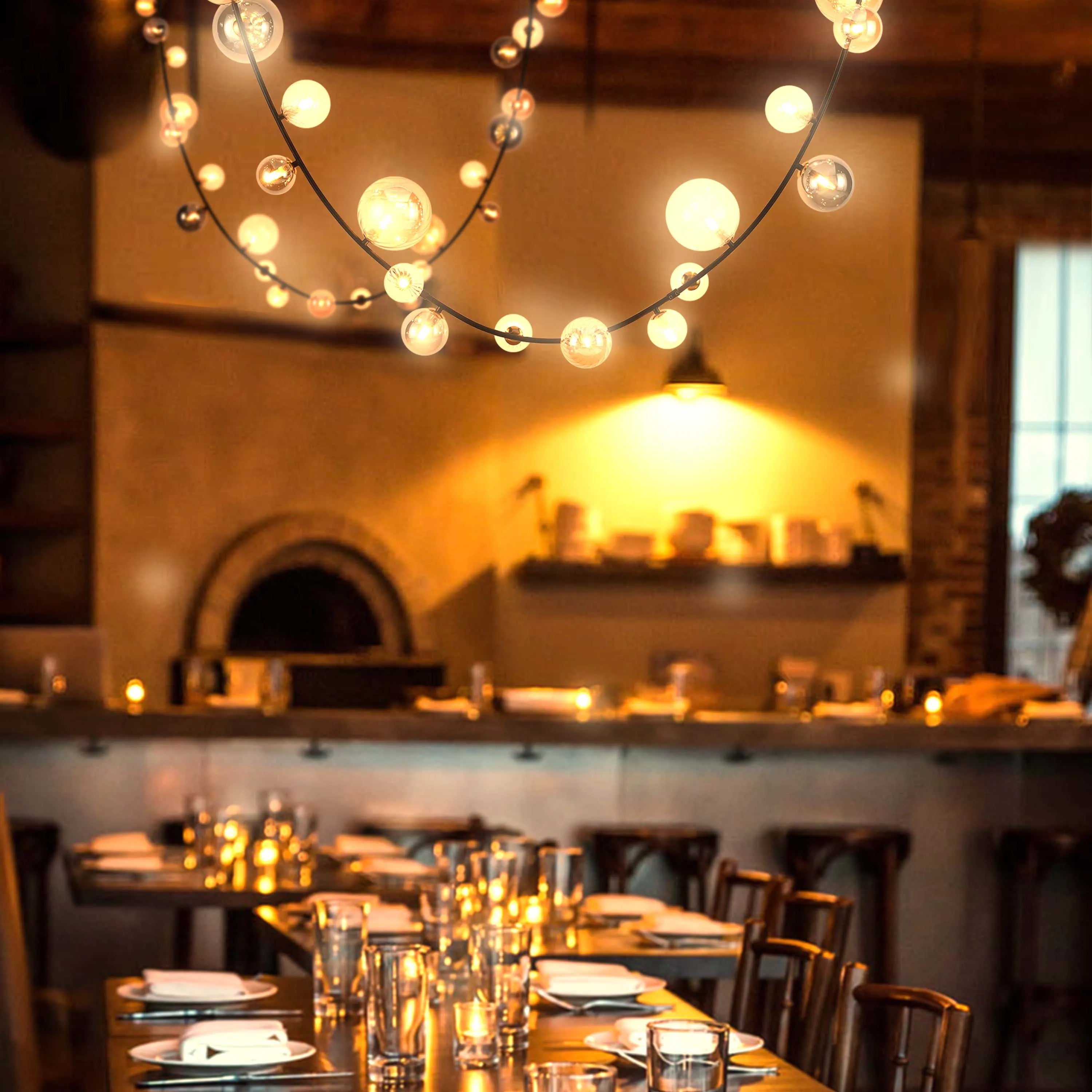 Atmospheric lighting with globe string lights over tables, creating a warm, inviting restaurant ambience.