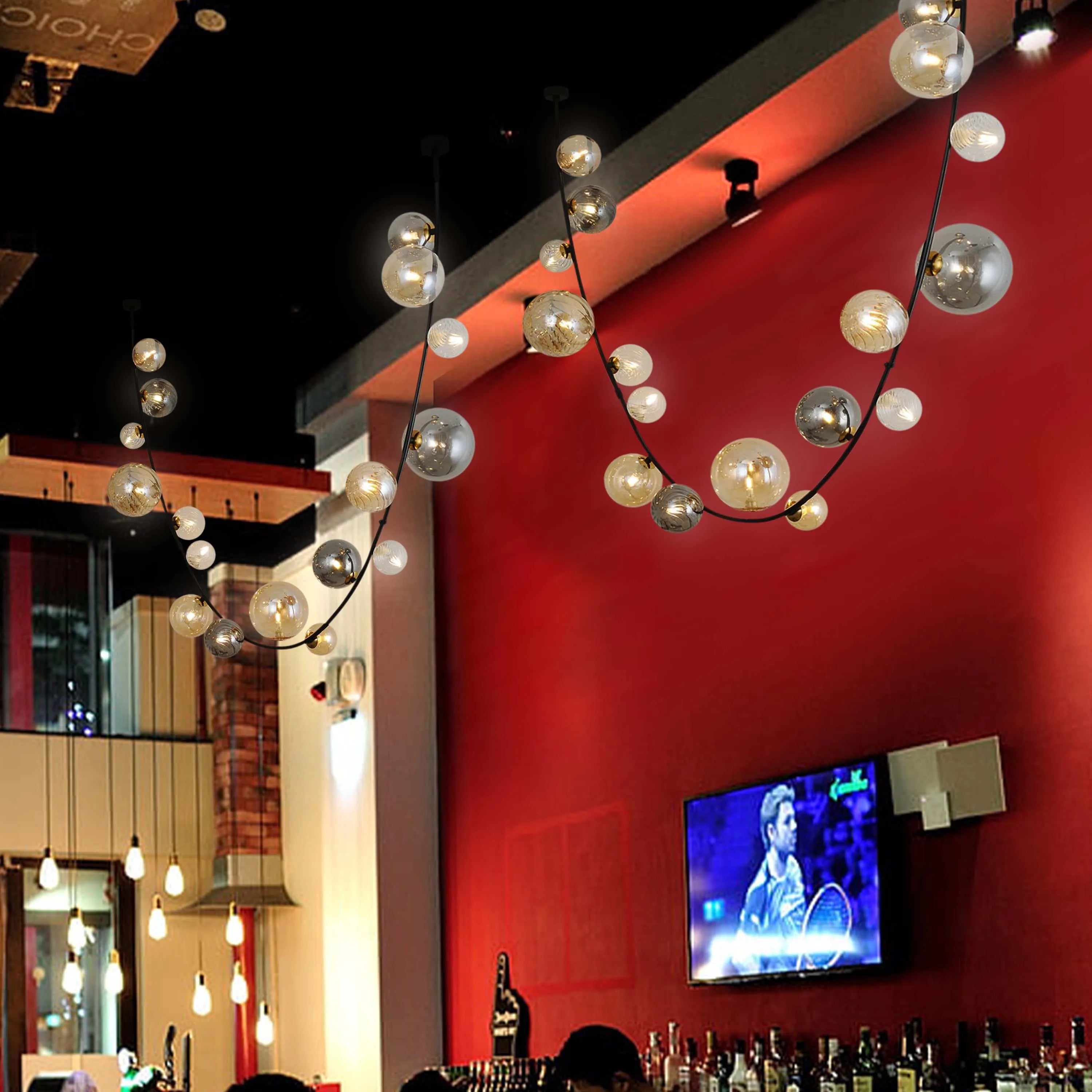 A modern, decorative lighting fixture featuring glass orbs suspended on a curved black metal rod, creating an elegant and ambient glow.