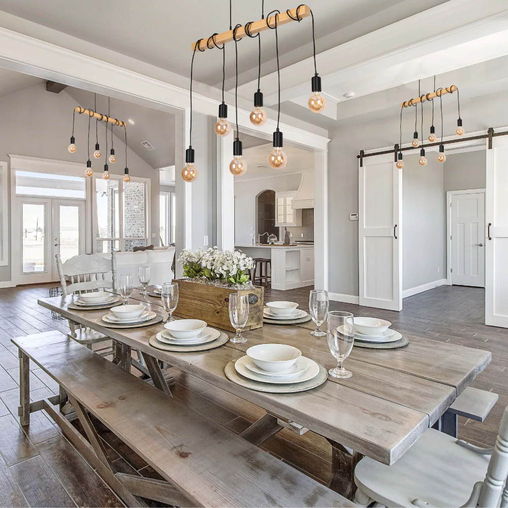 Stylish dining area with pendant lights. Exposed bulbs hang from a wooden beam, creating a warm and inviting atmosphere.