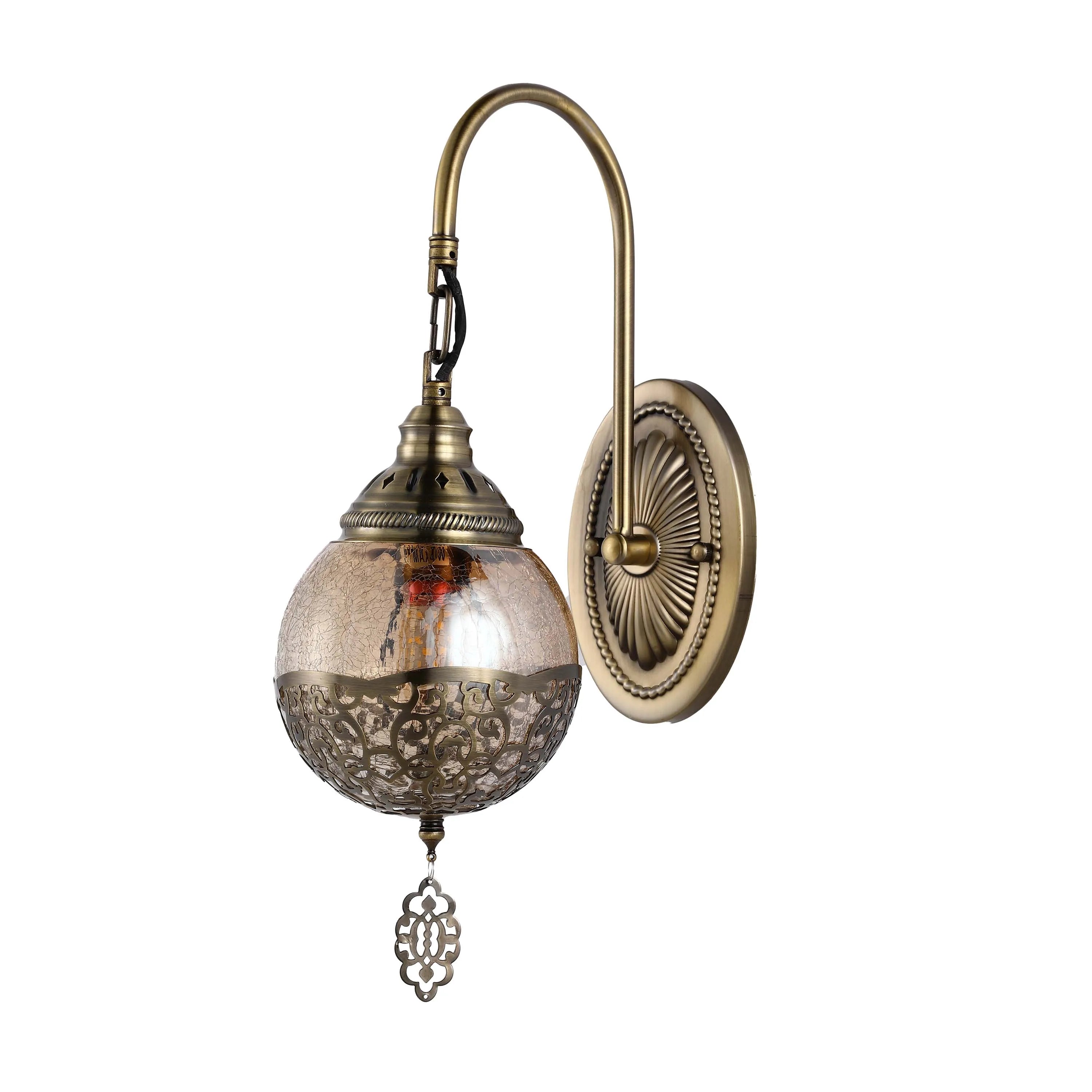Antique brass wall light with ornate globe shade and filigree detailing, bringing vintage charm to any room.
