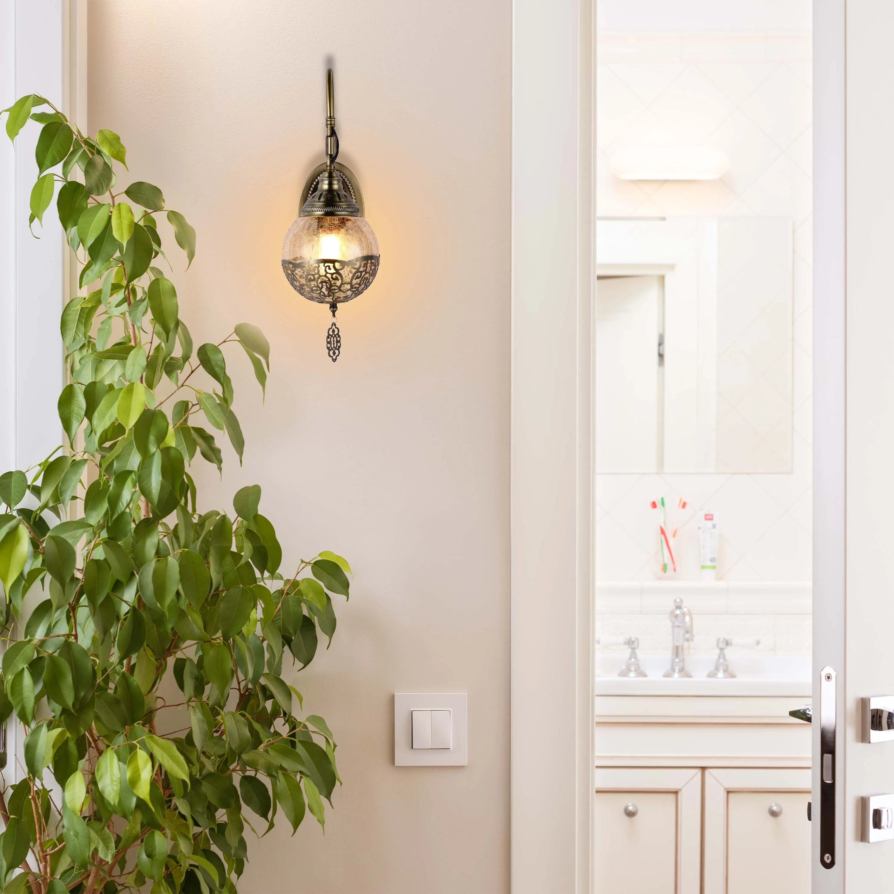 A decorative, traditional wall light illuminates the hallway, casting a warm glow in this inviting space.