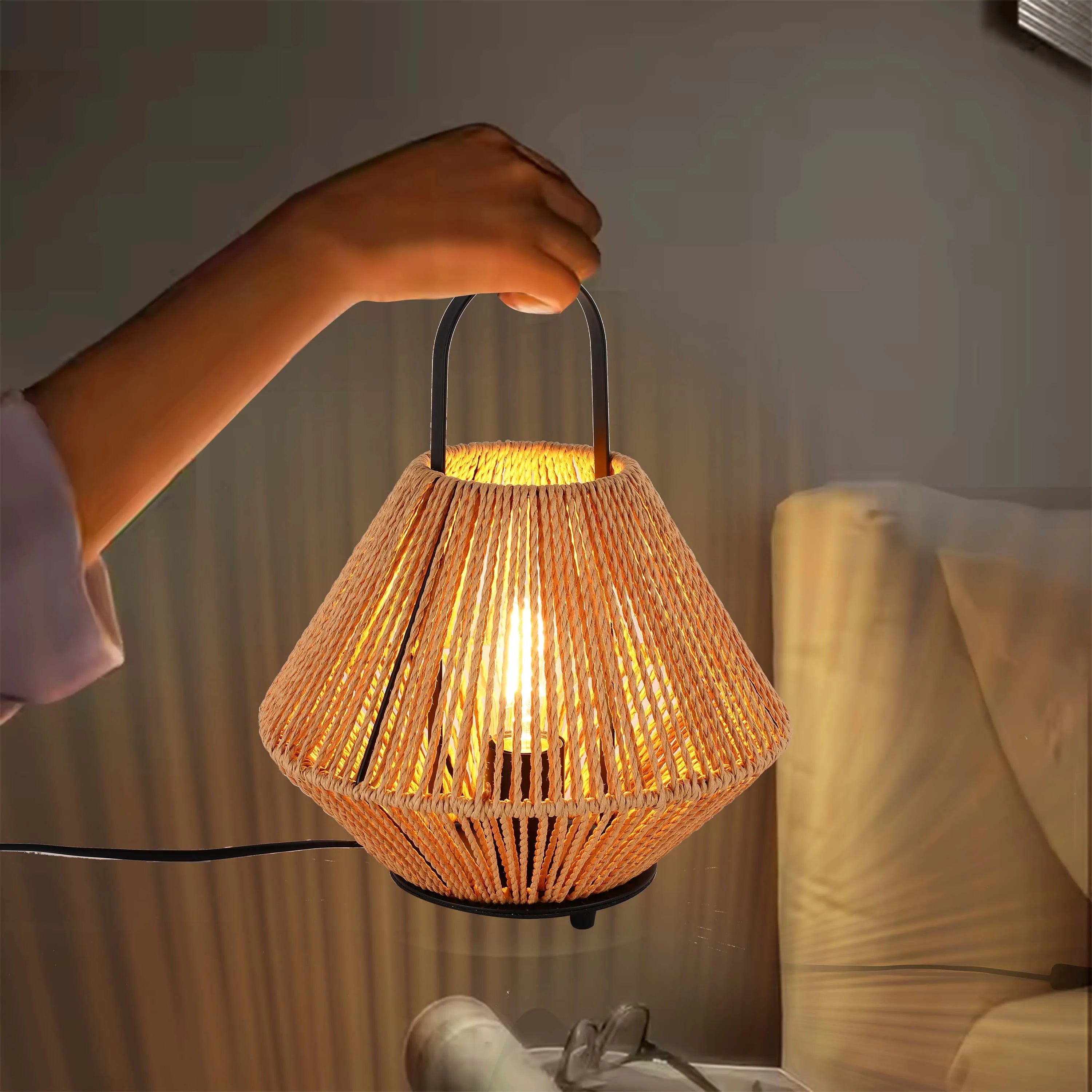 A person holds a lit, rope-covered lantern. The lamp gives off a warm, ambient glow.
