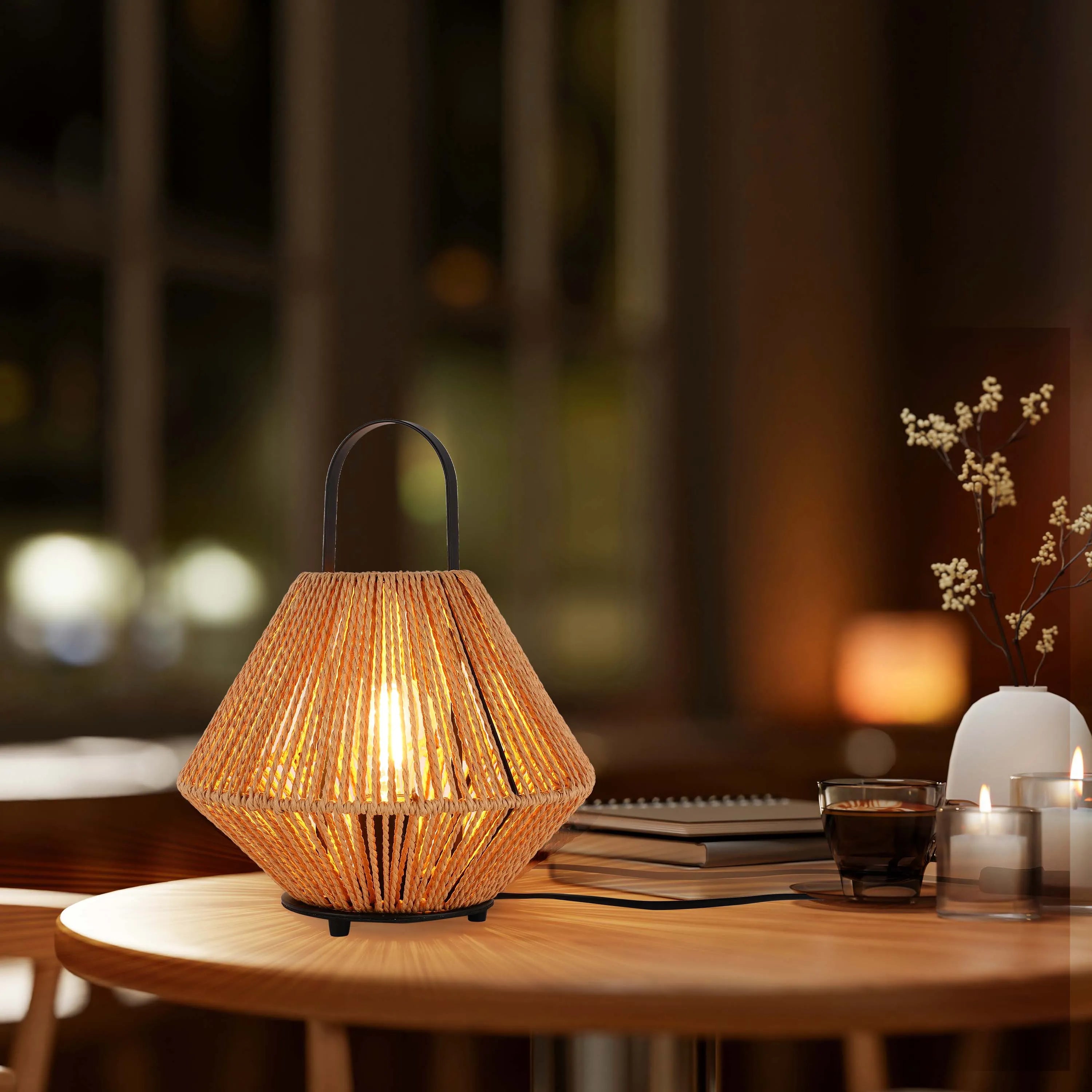 A table lamp with a woven shade, casting a warm glow. Accented with candles, books, and a vase for a cosy ambiance.
