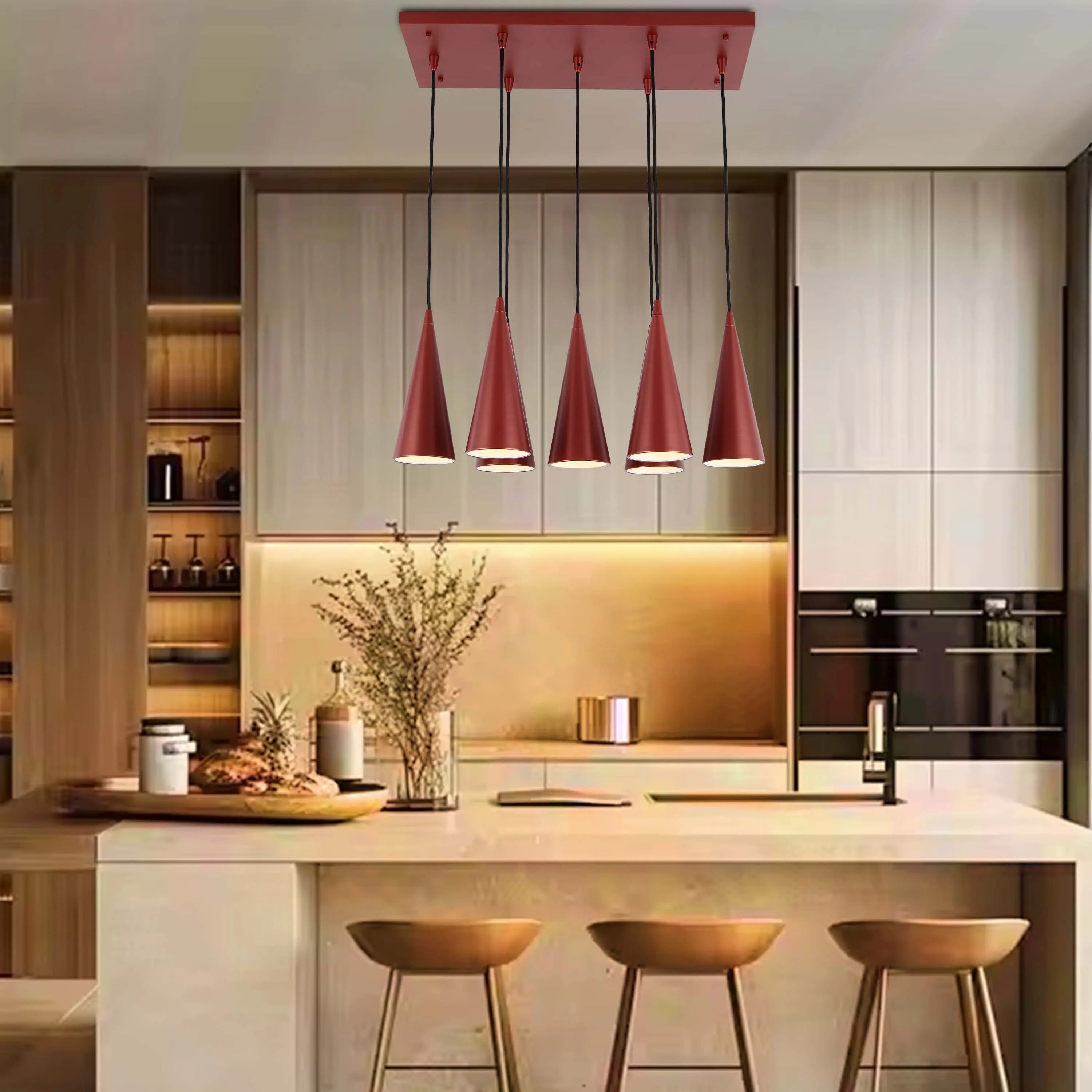 A modern kitchen island illuminated by a stylish, five-light, copper pendant lighting fixture.