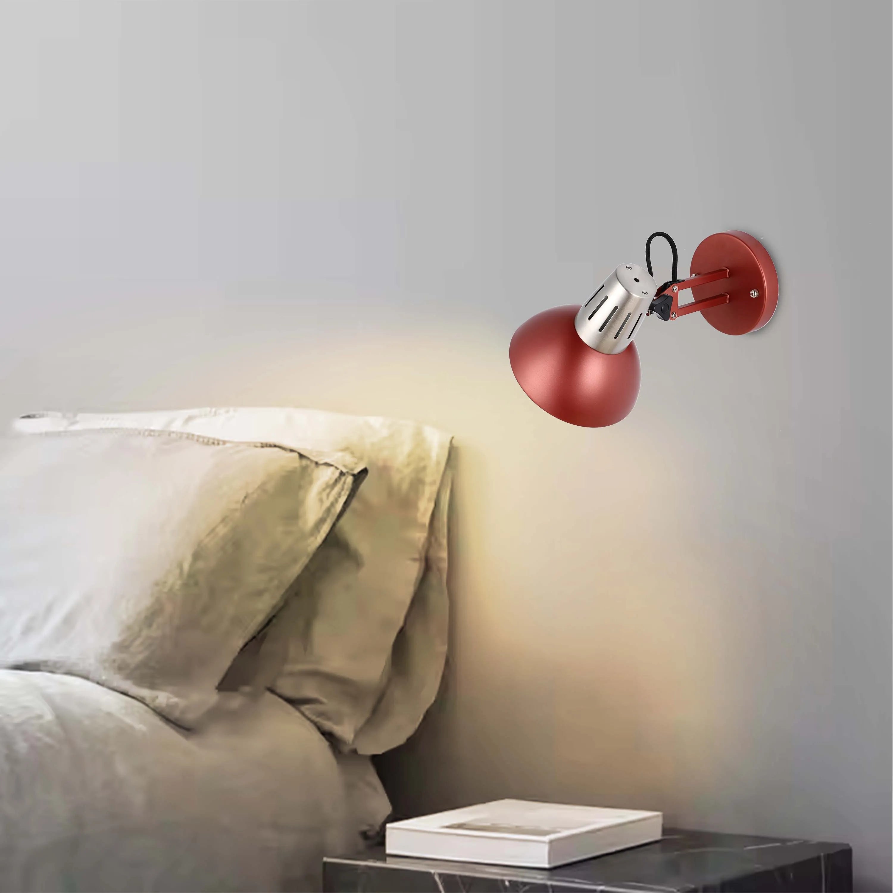A modern red and silver wall light emitting a warm glow. Perfect for bedside reading or adding a stylish touch to any room.