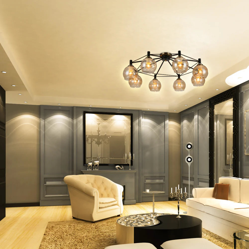 A contemporary, eight-bulb chandelier-style ceiling light fixture with spherical, amber-tinted glass shades, illuminating a stylish living room.