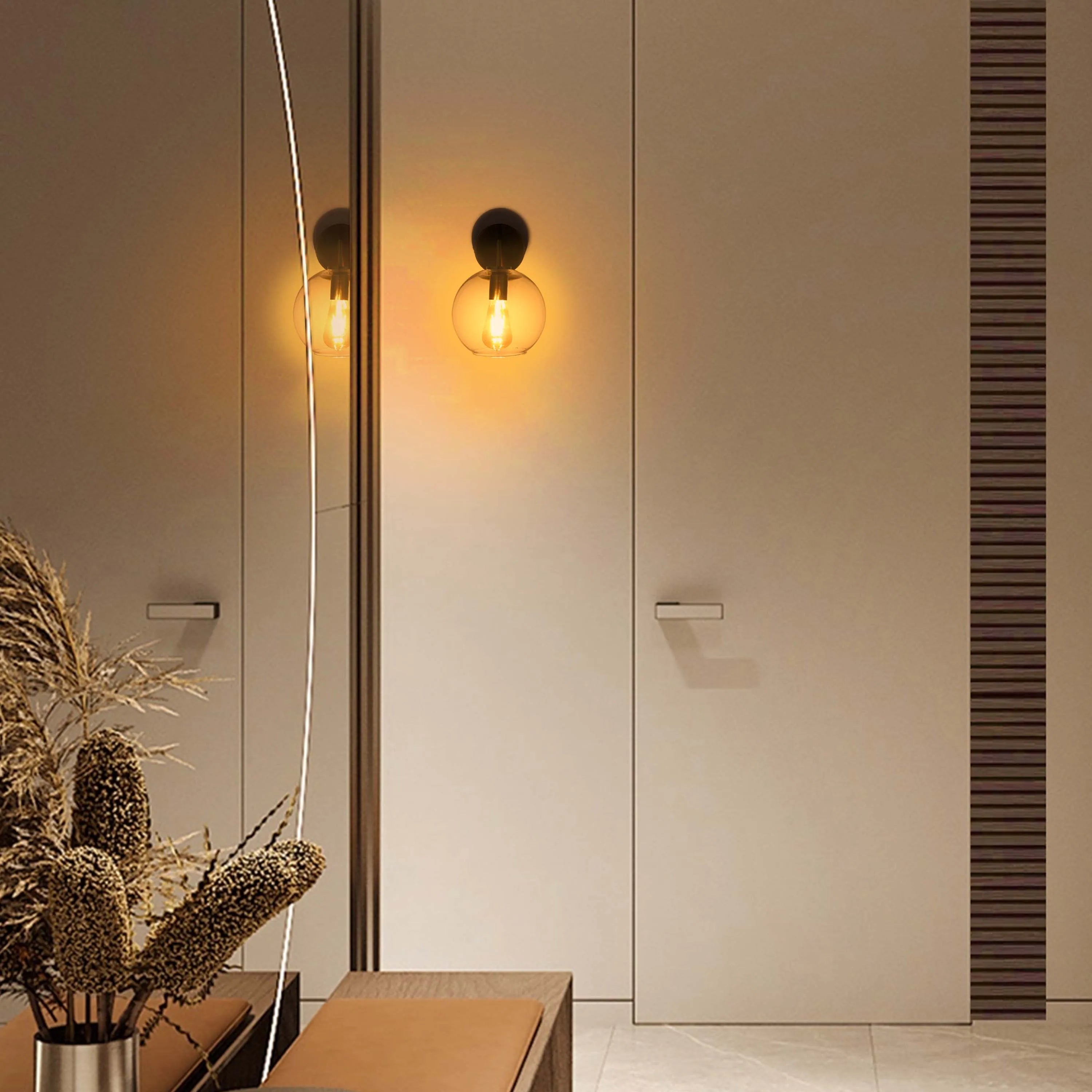A spherical wall light emits a warm glow, mounted beside a modern door. A stylish and minimalist lighting choice.